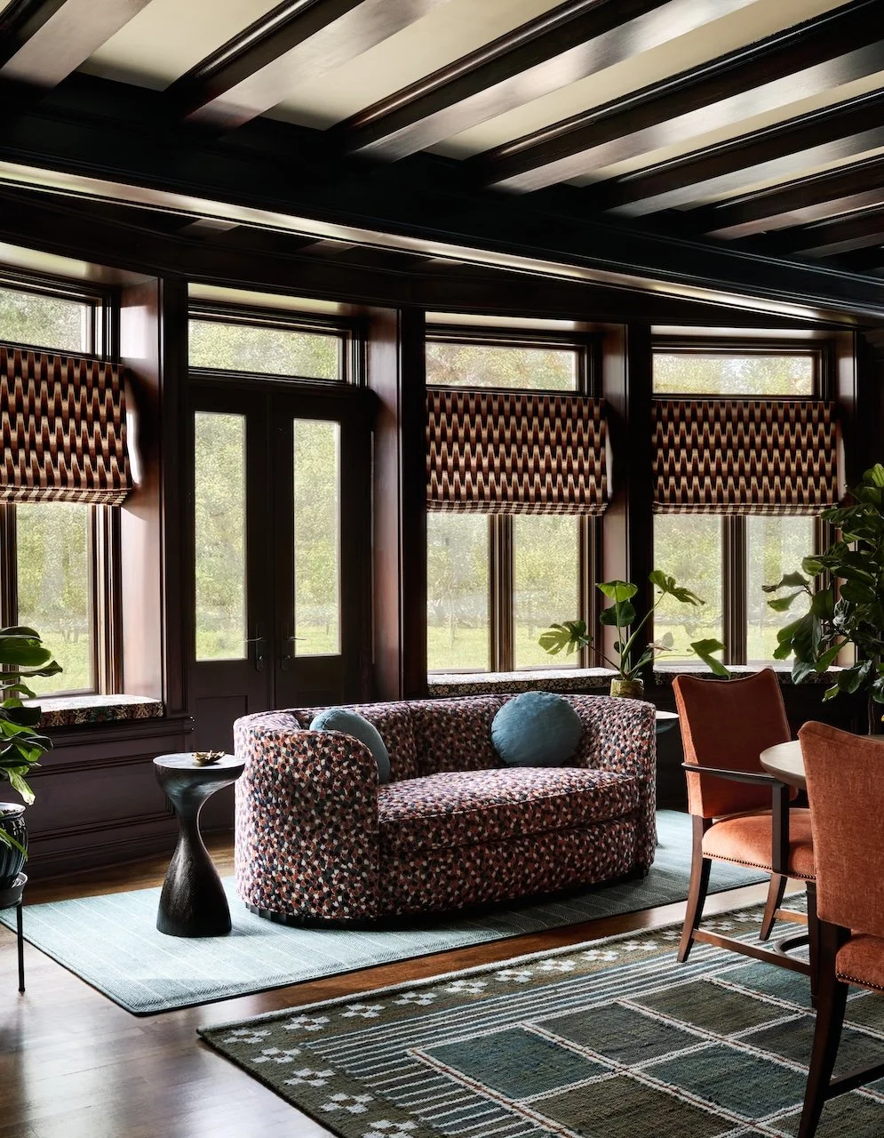 Traditional dining room patterned roman shades curved loveseat layered rugs window seats