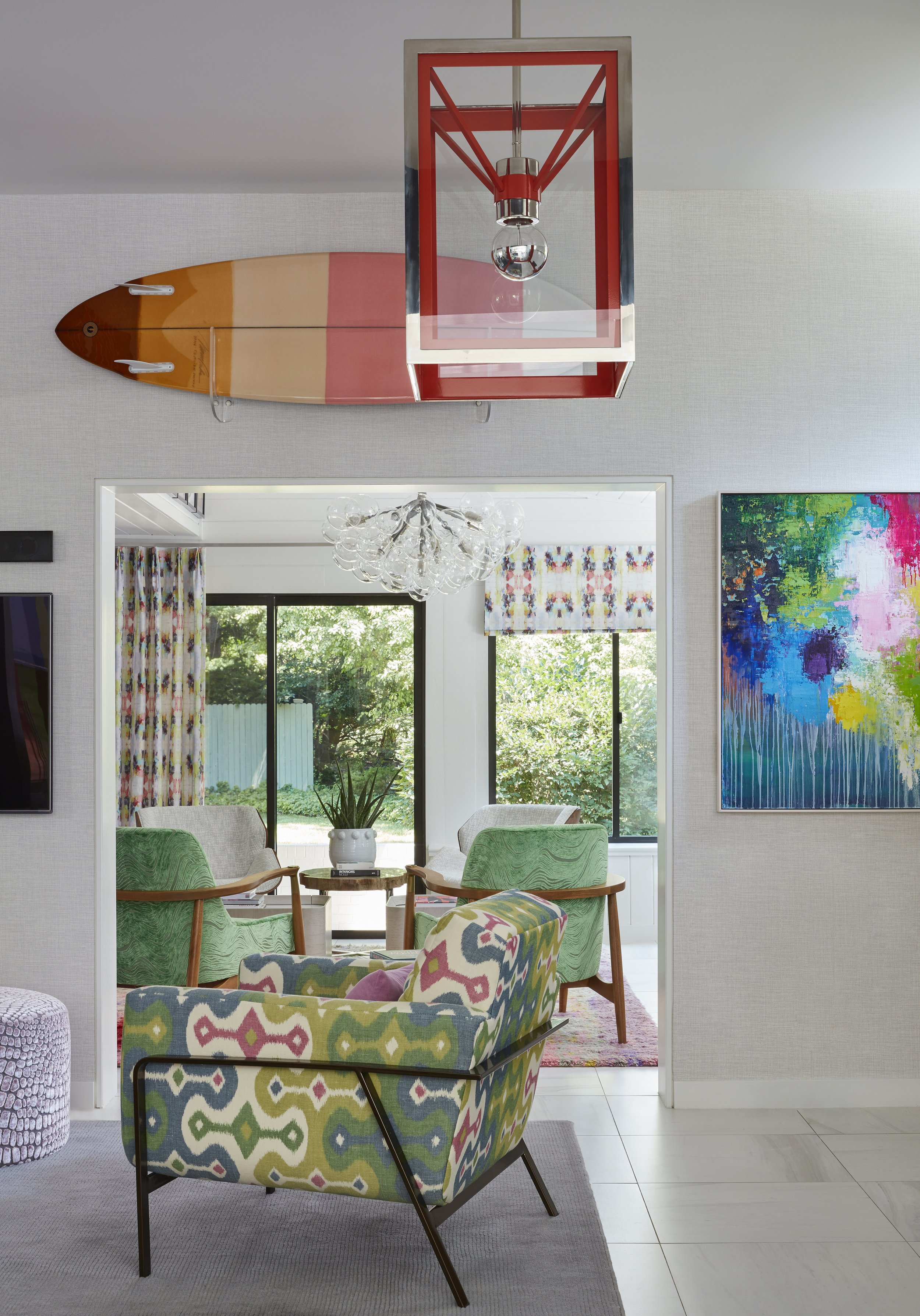 cozy lounge chair in bright colors for family room with red pendant light and modern artwork