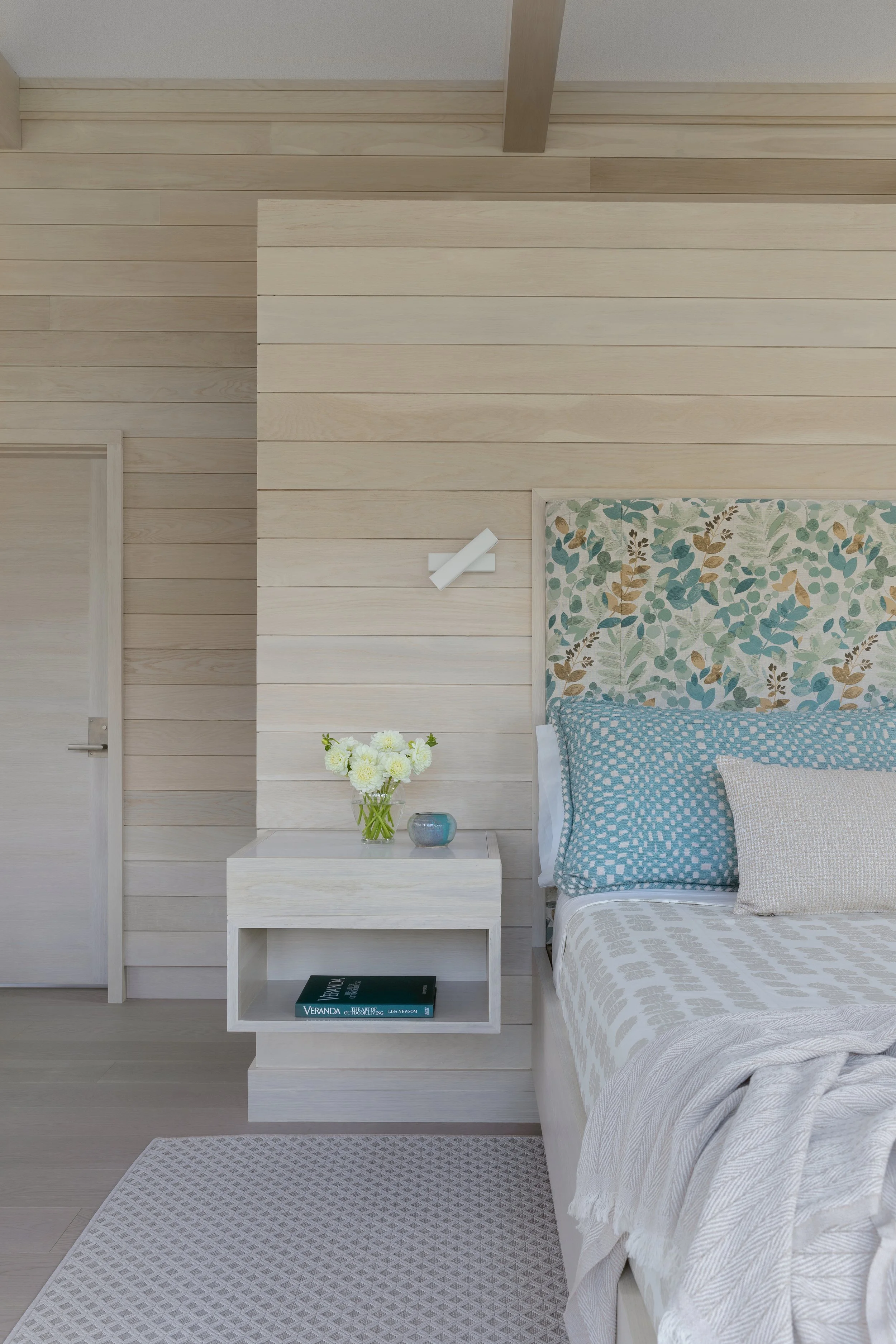 modern bedroom with floating nightstand and wall sconces for reading