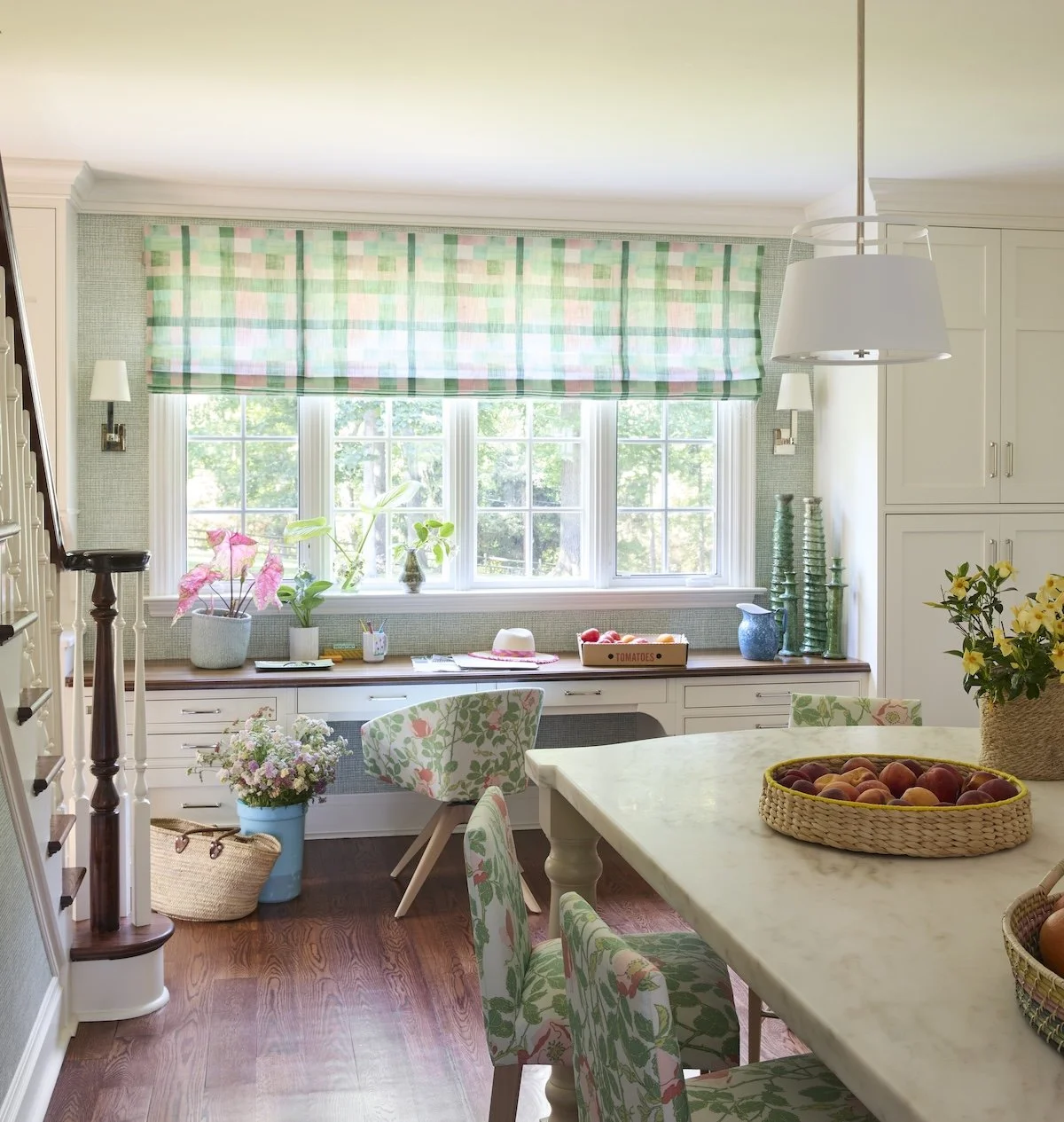 12 Bright kitchen desk nook with green and pink plaid roman shade, built in white desk, floral upholstered chairs and marble island by Betsy Wentz