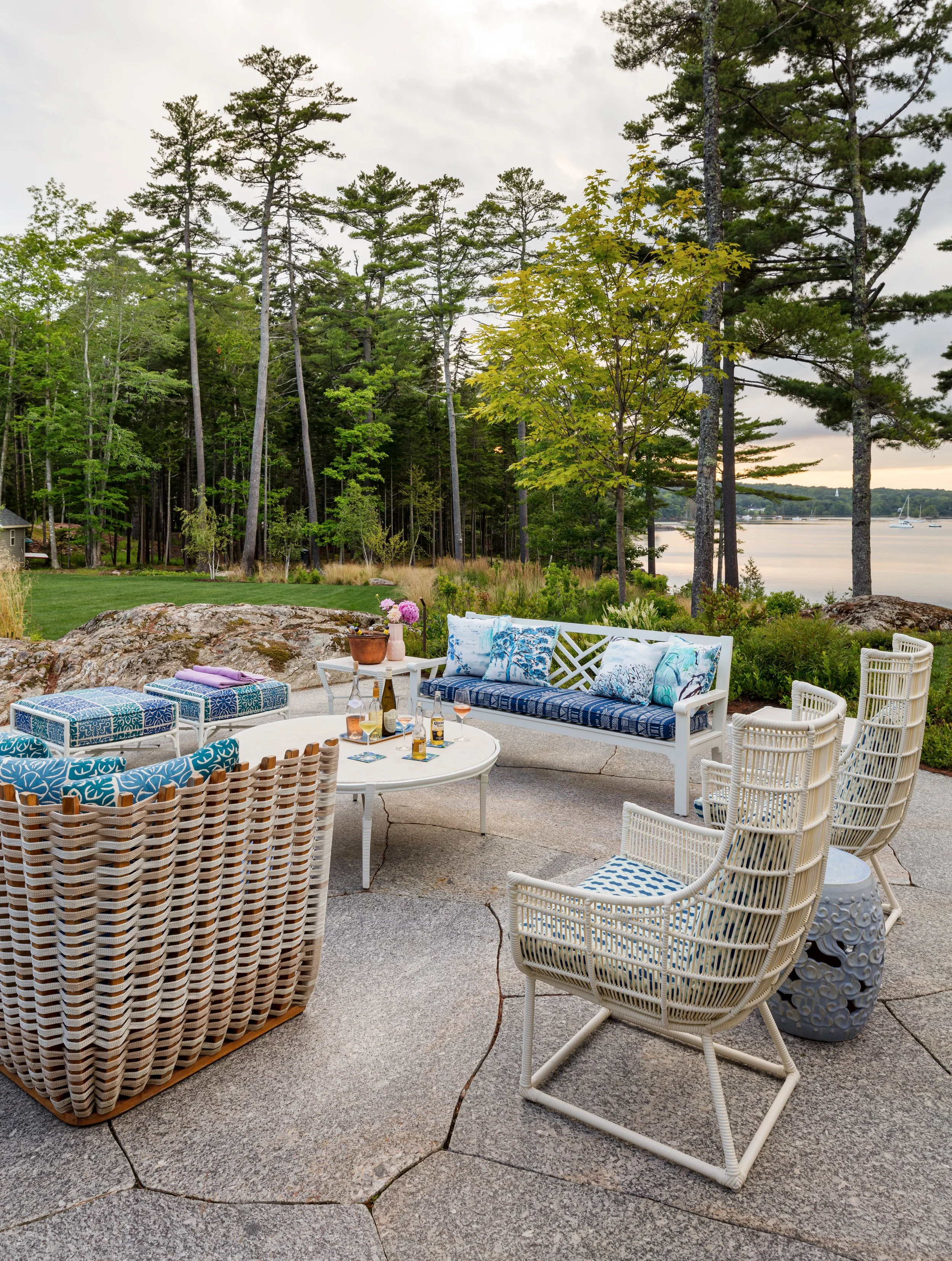 coastal-lakefront-outdoor-seating-area-with-wicker-chairs-and-blue-patterned-cushions.jpg