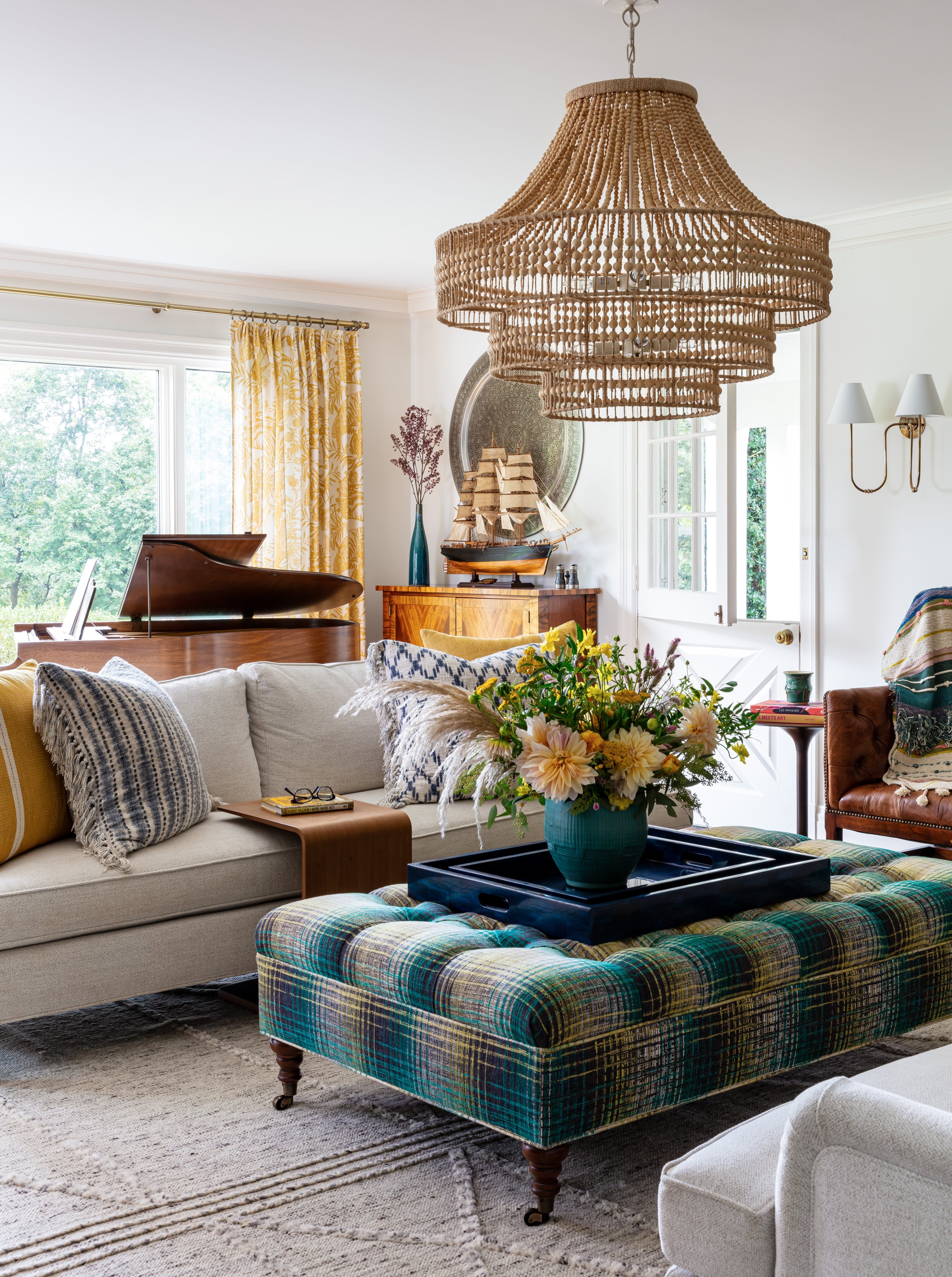 traditional living room with neutral sofas rug colorful ottoman and beaded chandelier