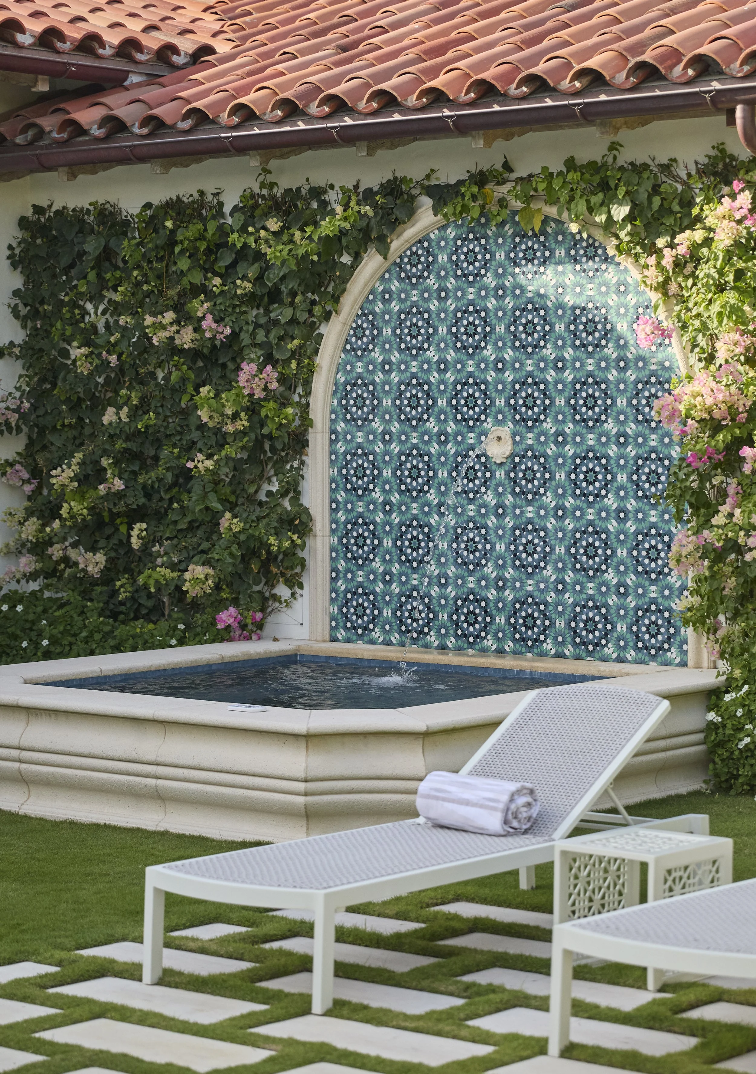 mediterranean style fountain with tiled wall and floral vine accent design for relaxing backyard retreat