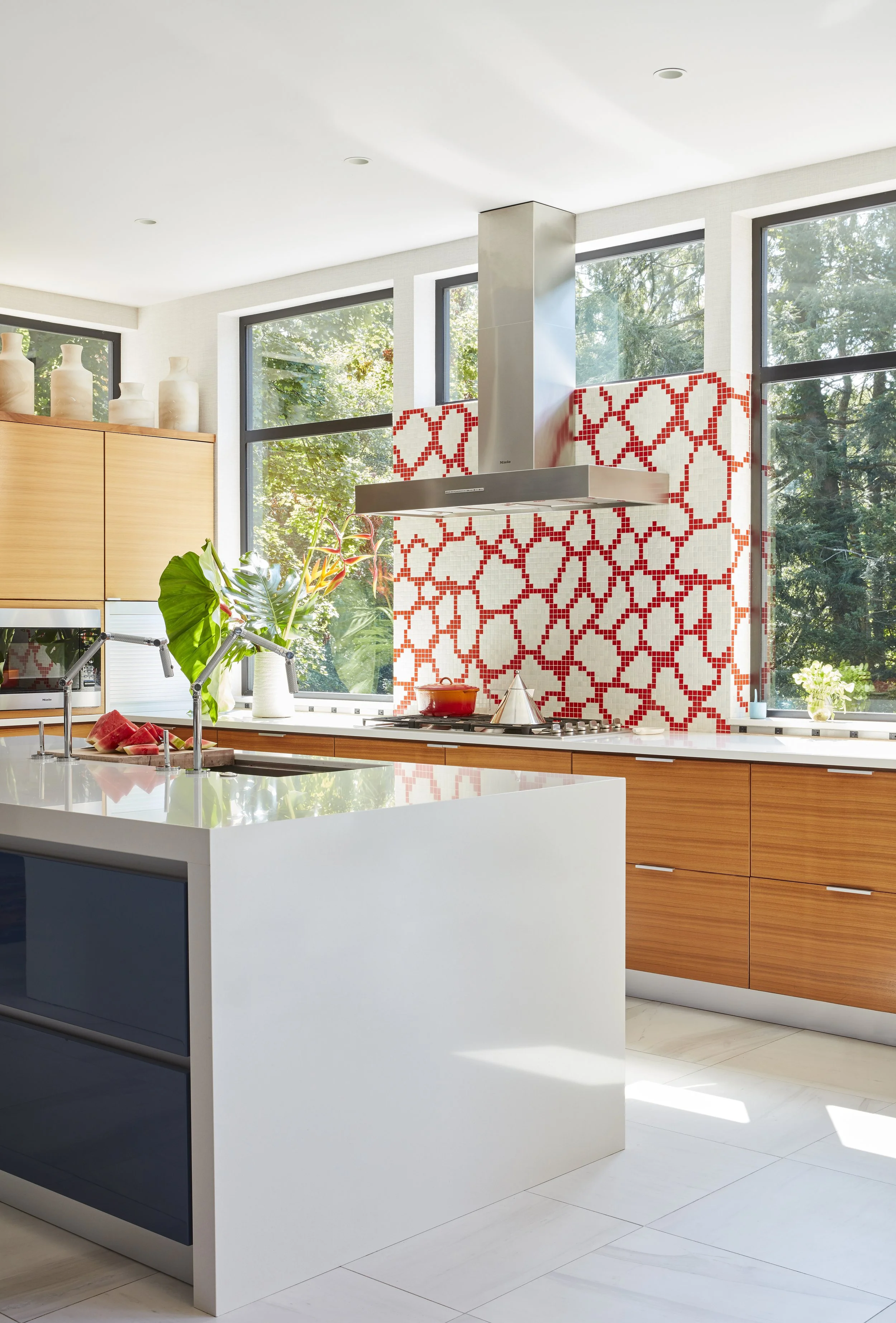 modern kitchen renovation with statement backsplash hood and lots of windows