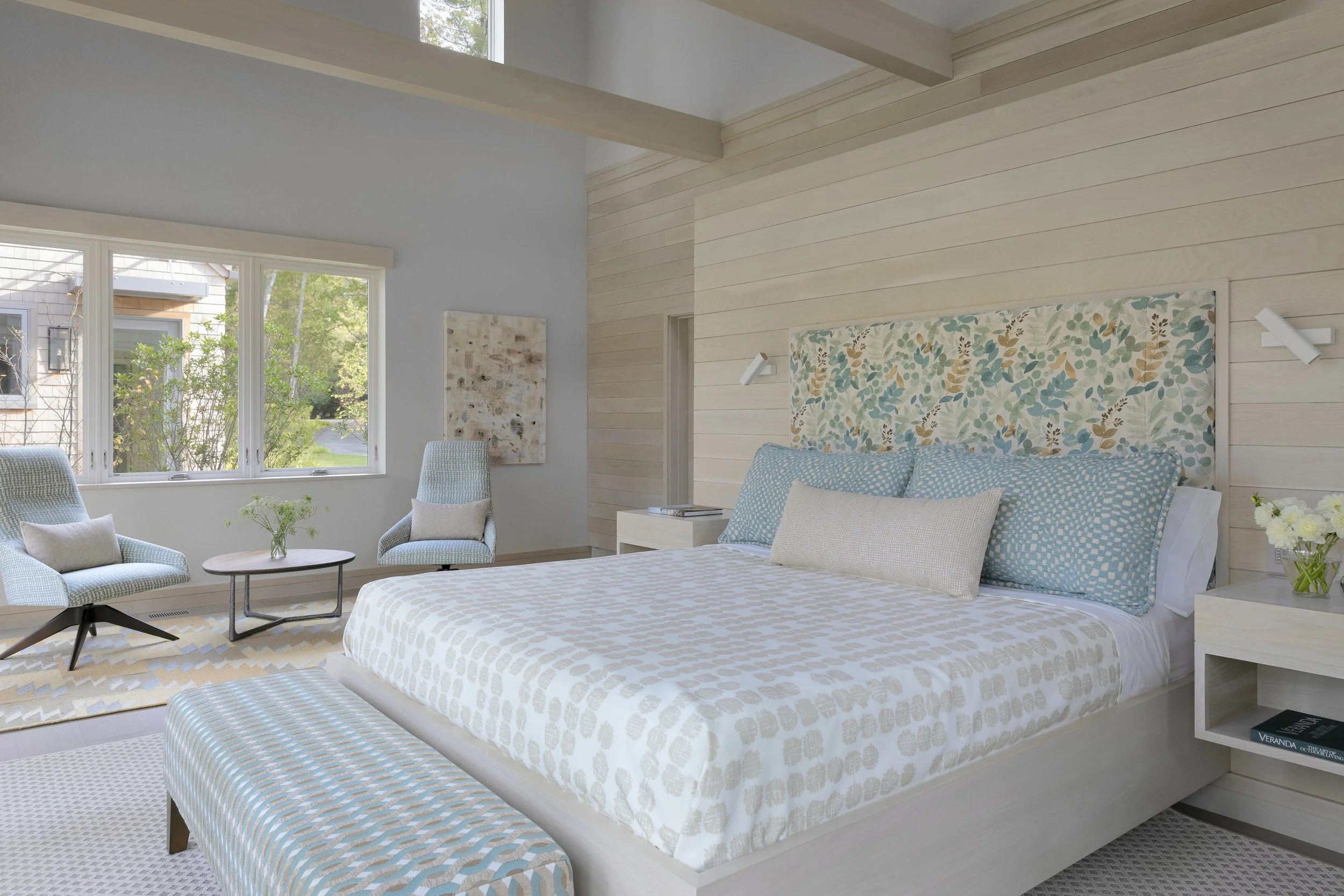 sleek bedroom in neutral colors with bench for bedroom and comfortable chairs