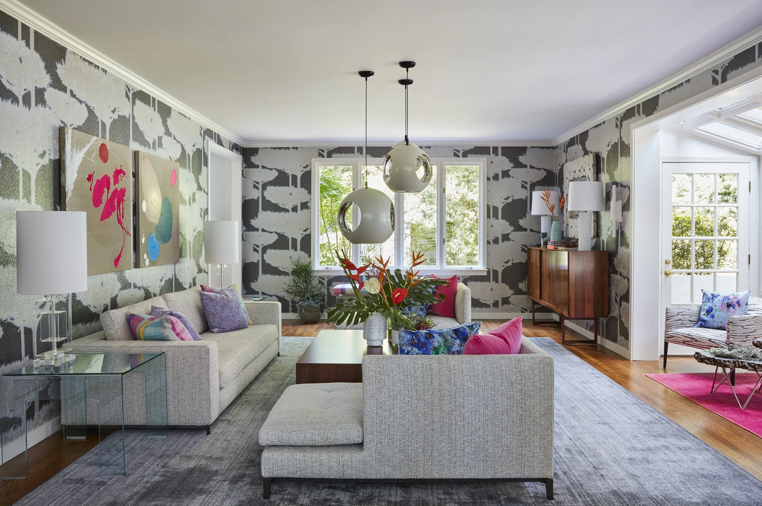 open concept living room with neutral sofas globe chandeliers large coffee table and colorful pillows
