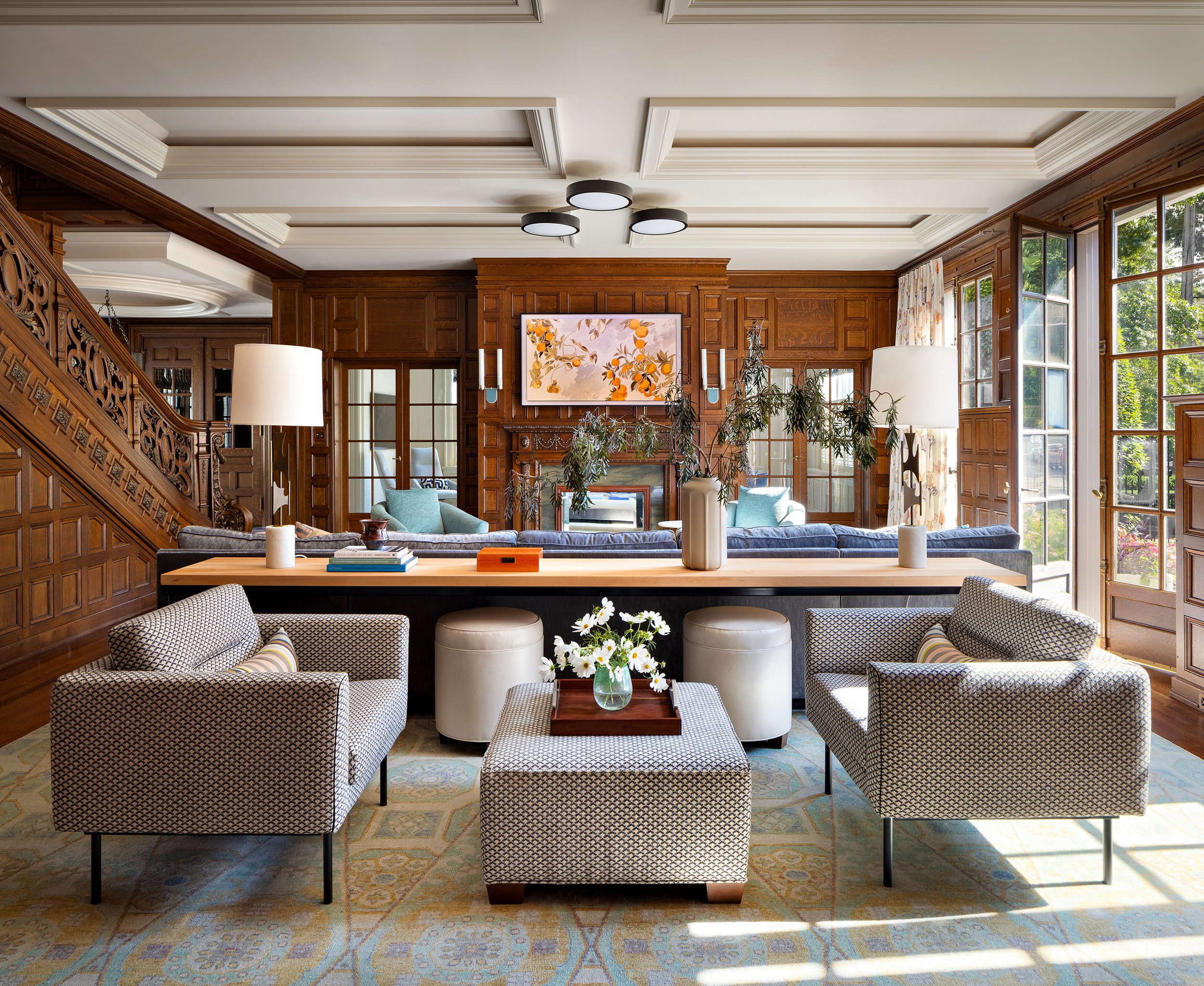 warm family room wood paneled walls long console with lounge chairs behind sectional for conversation area 