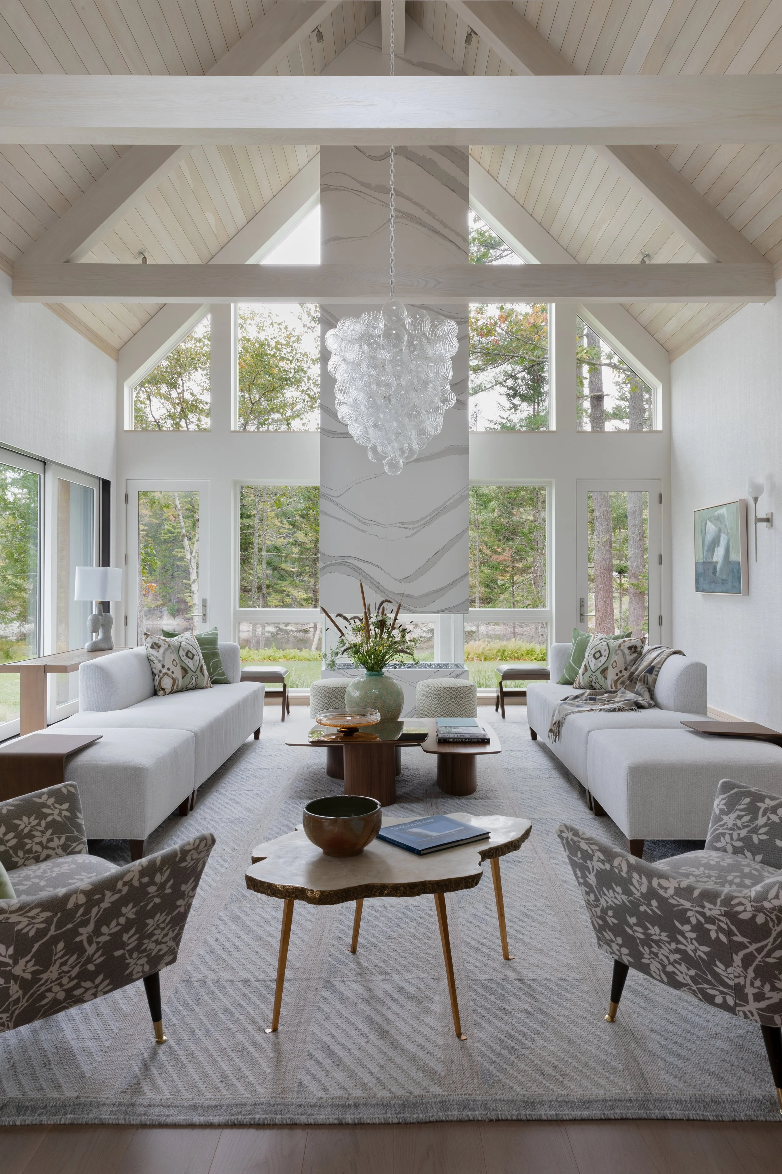 open flow living room with quartz slab two sided corner fireplace and comfortable white sofas 