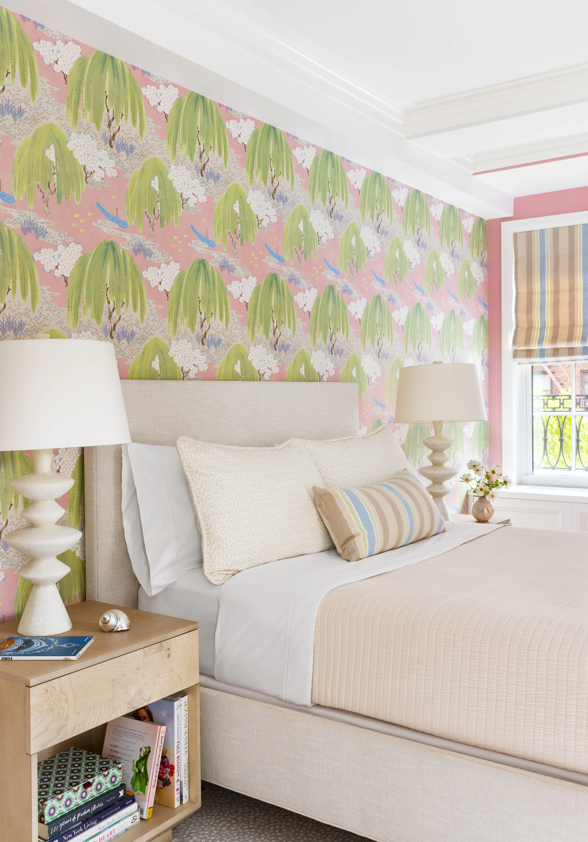 cozy bedroom soft pastel pink and green wallpaper comfortable bed end tables and lamps