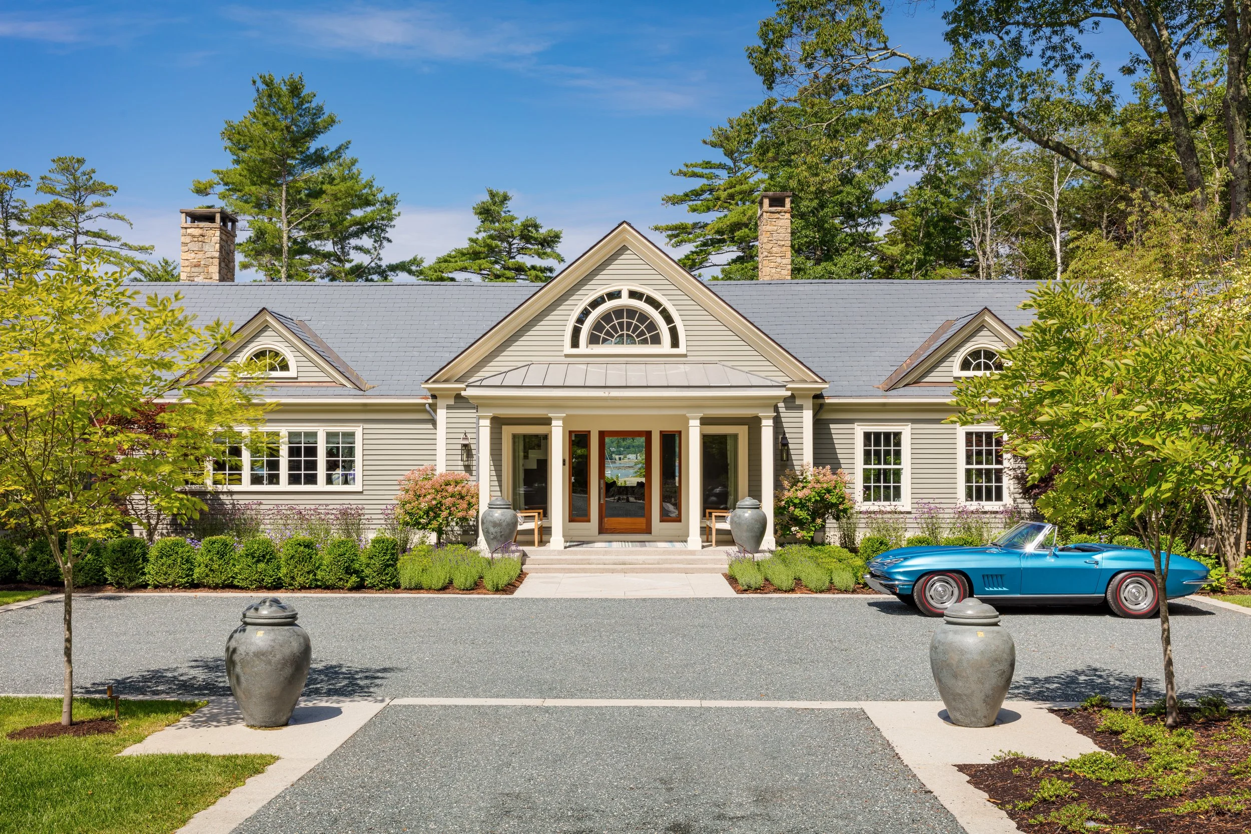 classic countryside style home exterior with gray roof beige siding and elegant front entry