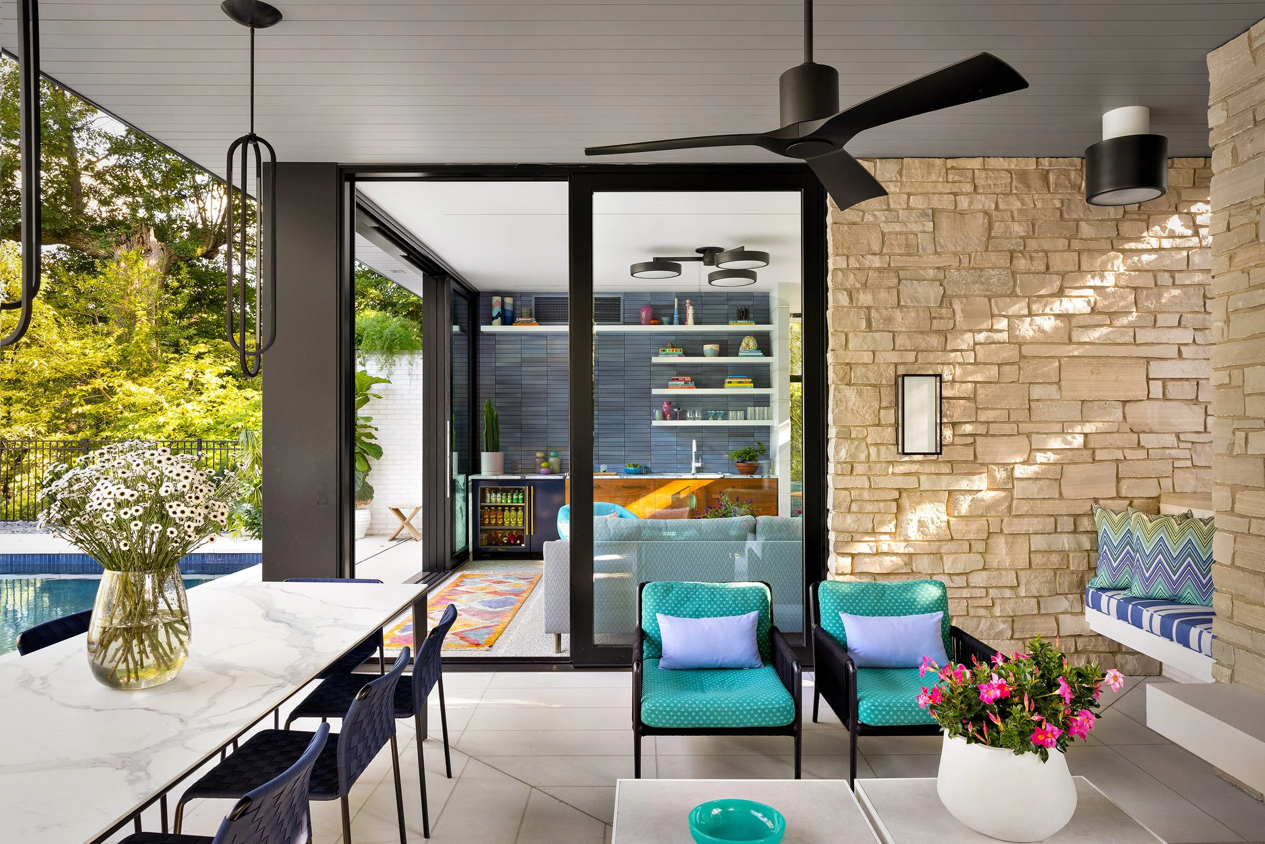 covered patio for alfresco dining with table chairs stone fireplace and seating area