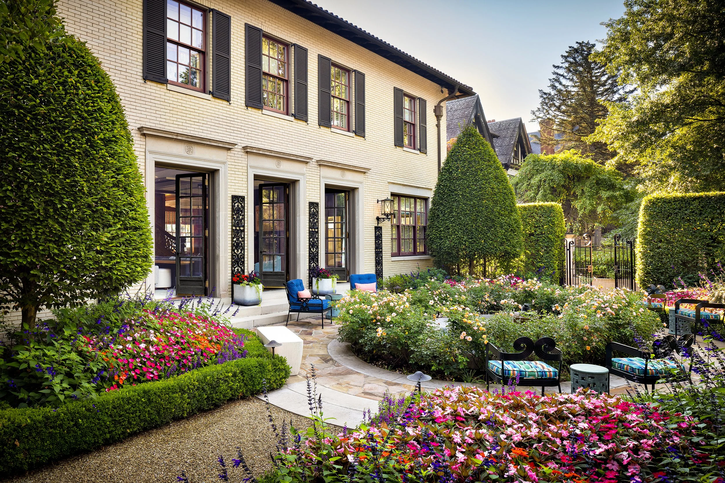stately house exterior with circle drive rose gardens and outdoor seating