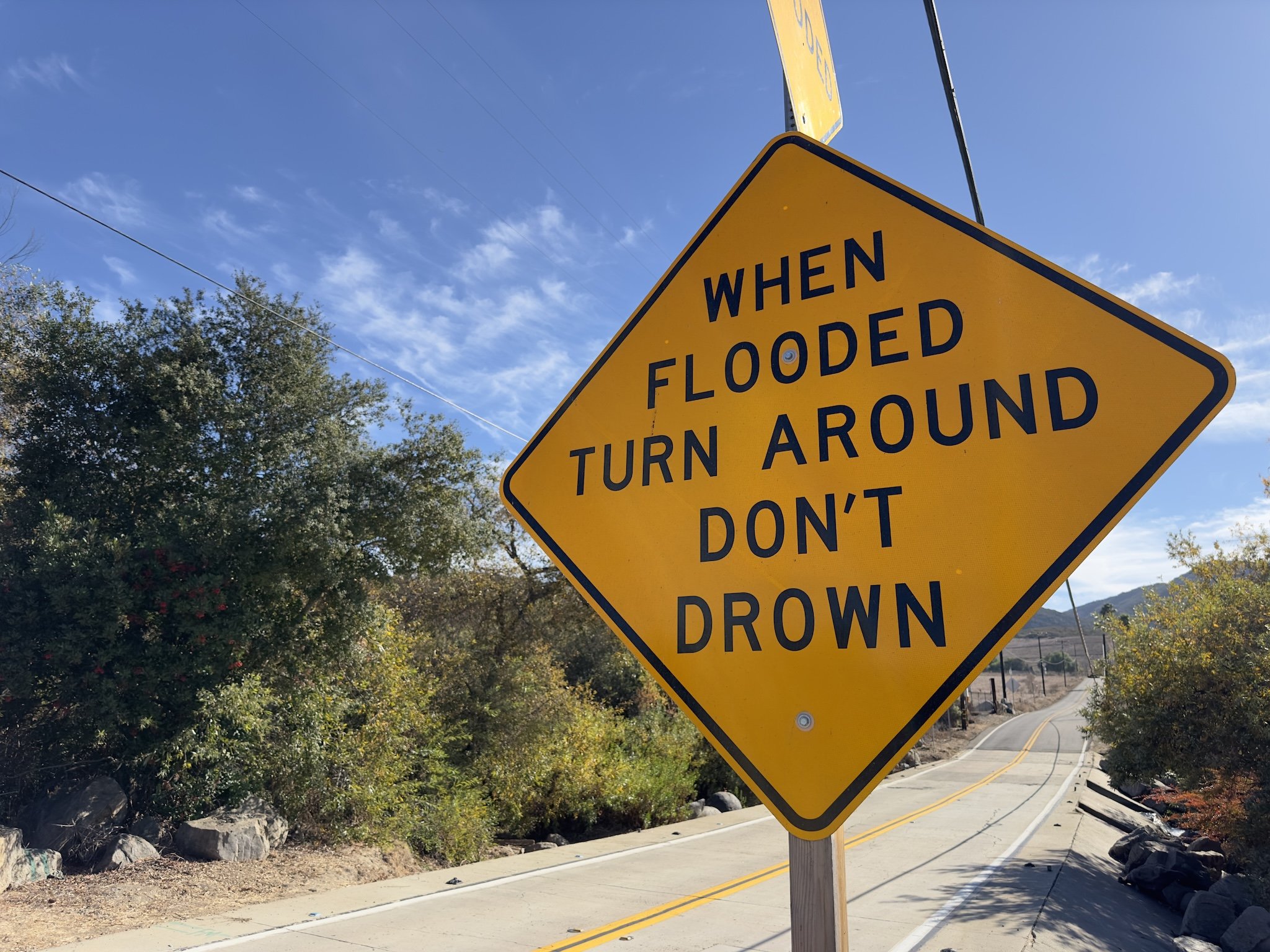 A flood warning sign in front of Escondido Creek. Nov. 23, 2024. (Jarrett Carpenter/Annenberg Media)