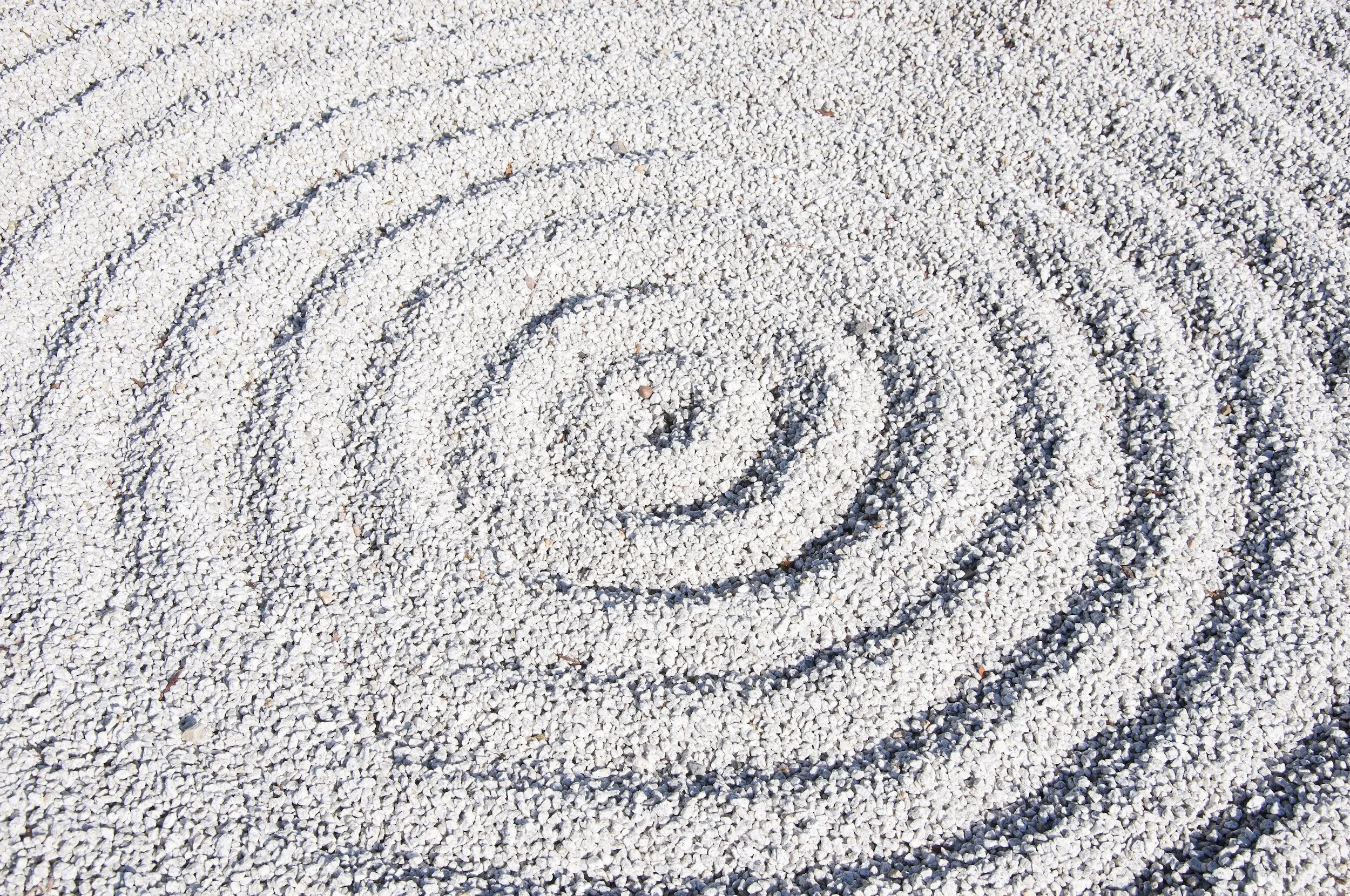 Spiral pattern drawn in white sand.