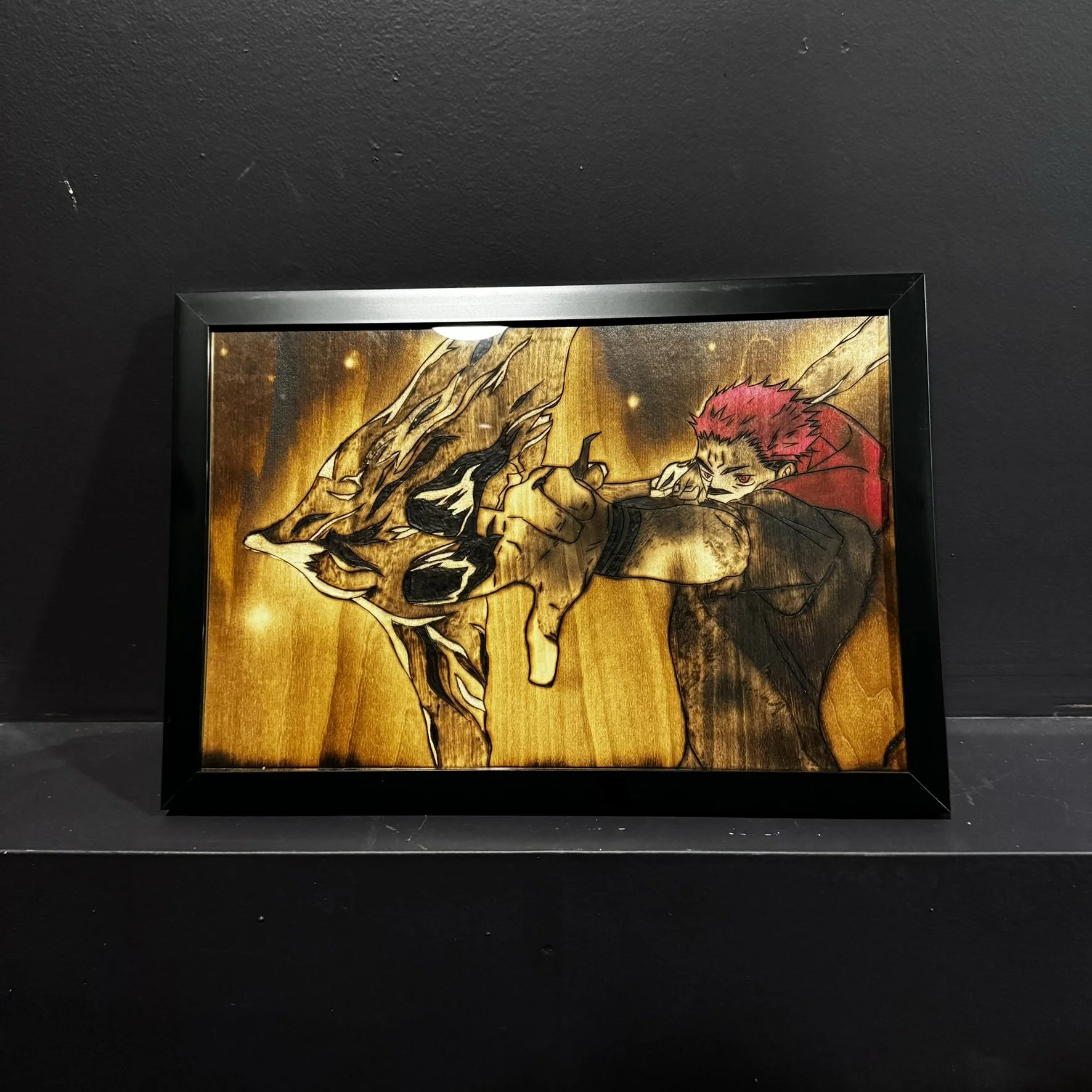 Framed artwork of a red-haired anime character wielding a flaming sword against a black background.