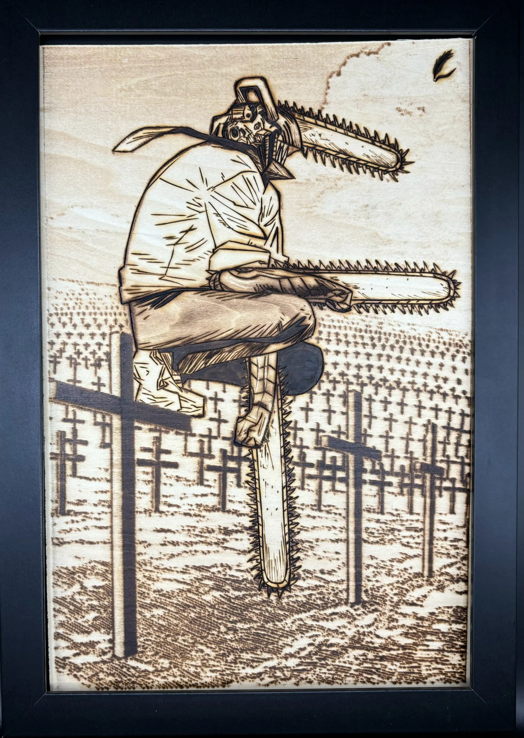 A woodburned artwork depicting a person with a chainsaw for a head, sitting on a log, with a landscape of cultivated land and telephone poles in the background.