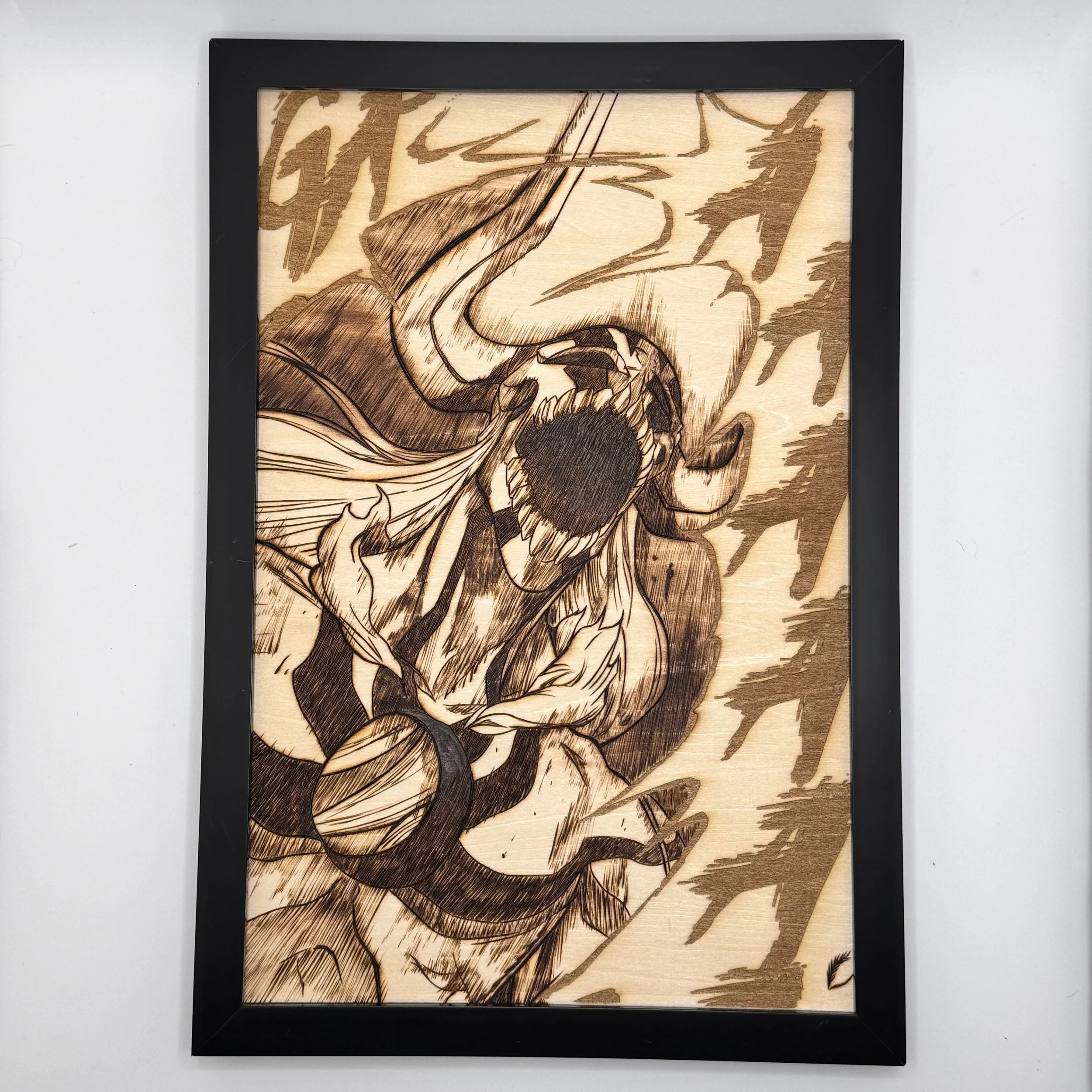 Wooden framed artwork depicting a stylized, aggressive creature with a large mouth, sharp teeth, and intense eyes, surrounded by dynamic lines and shapes.