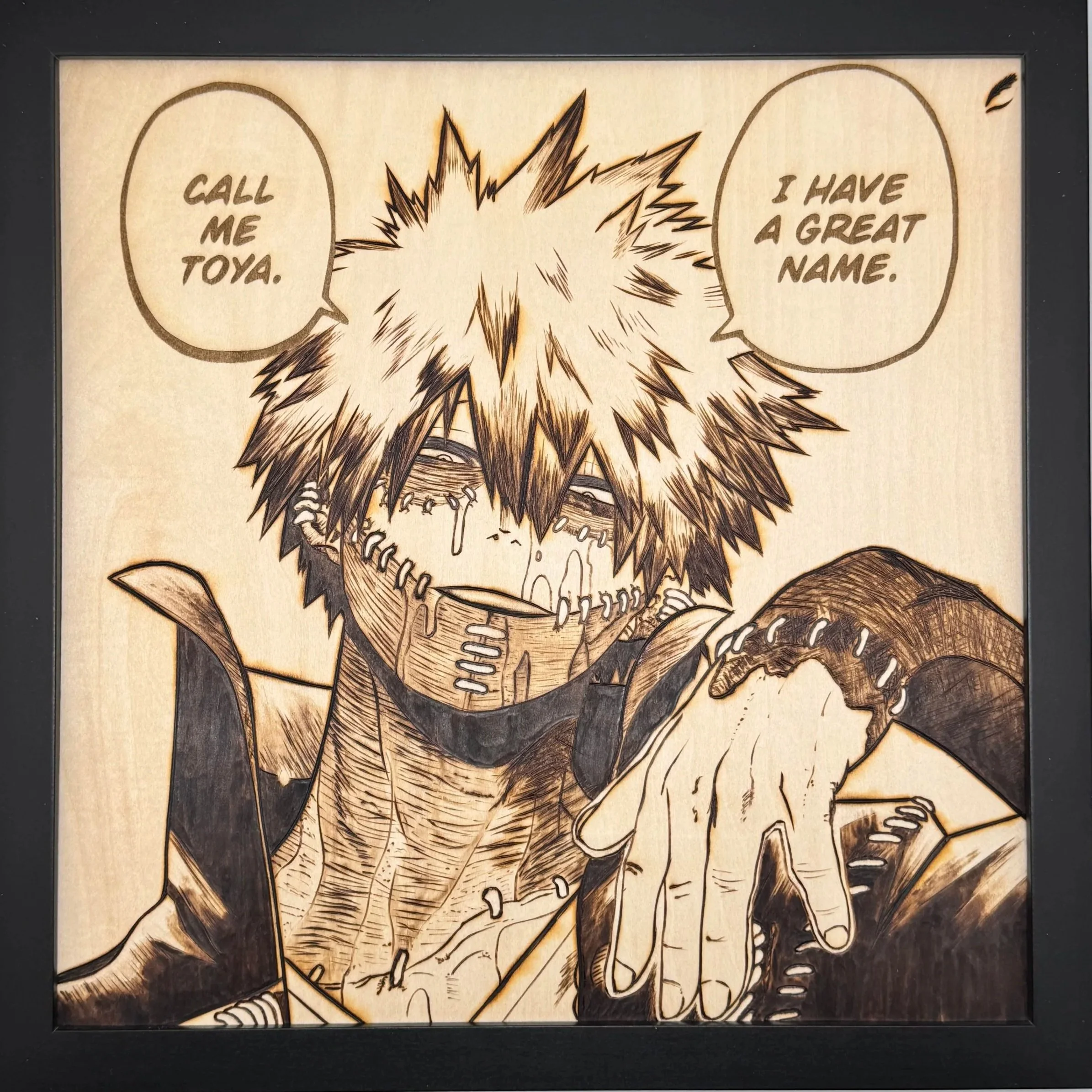 A framed artwork of a manga-style character with spiky hair, tears, and a stitched face, pointing with one hand. The character has speech bubbles stating, "Call me Toya" and "I have a great name."