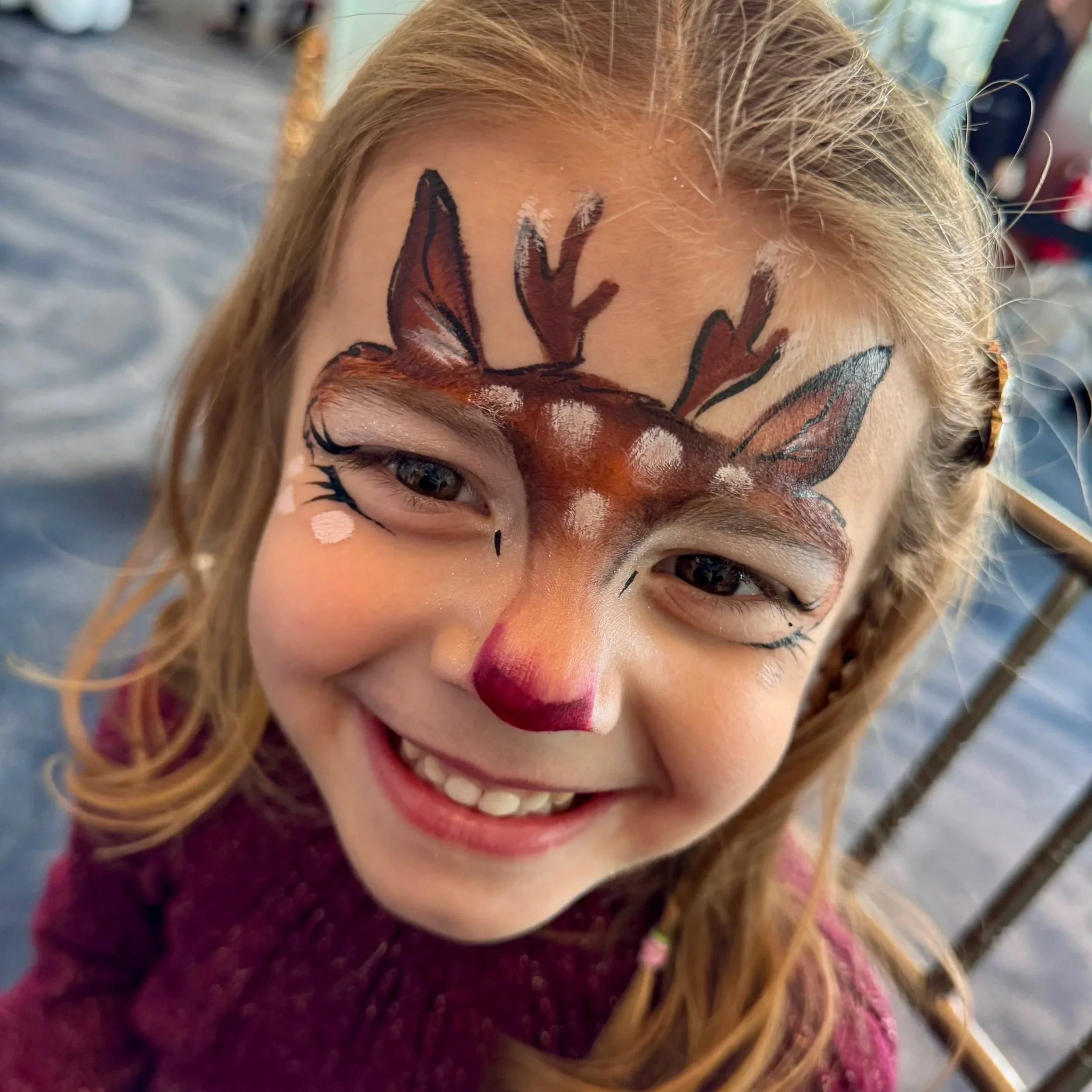 Professional holiday face painting for kids- cute reindeer design by Holiday Event Agency