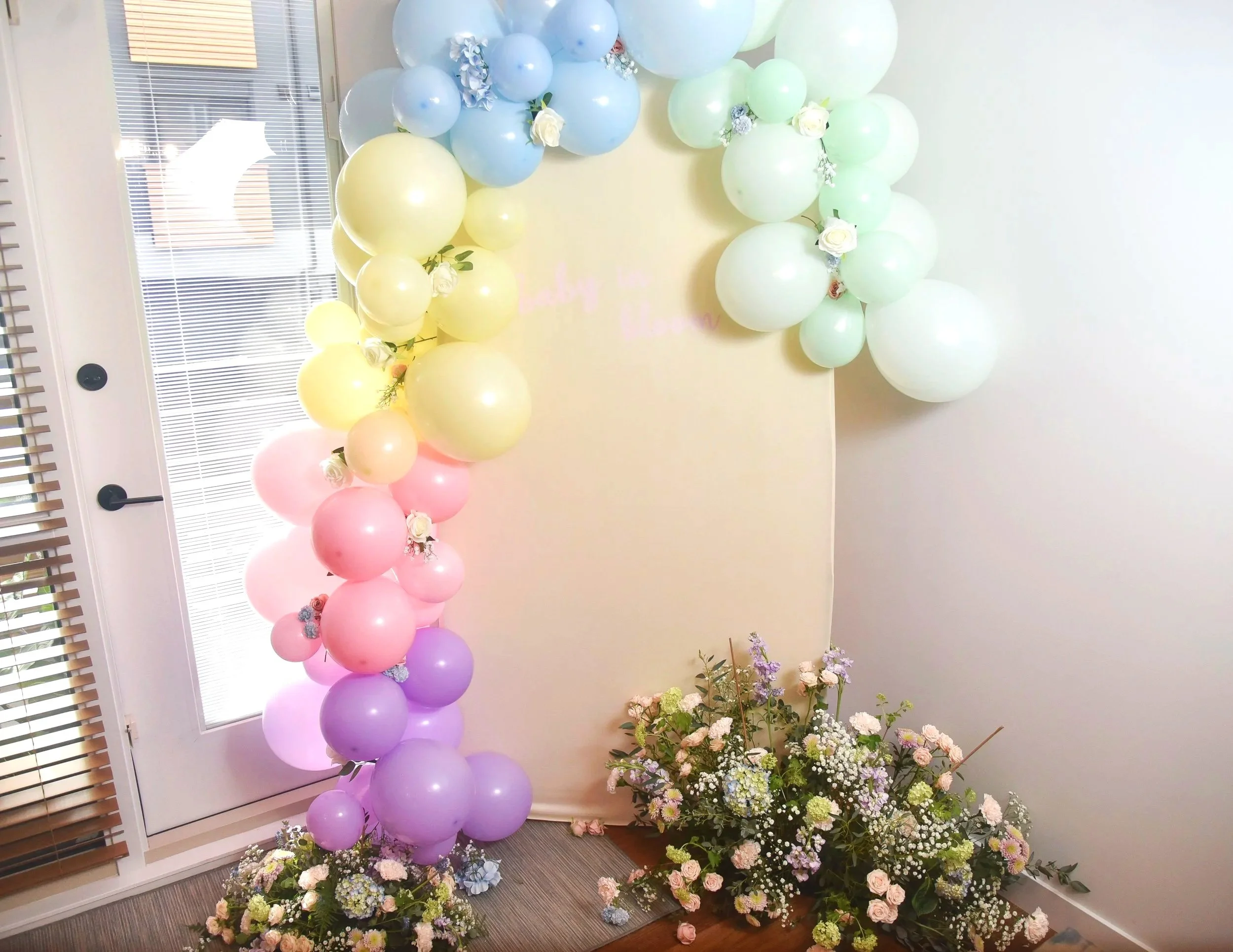 Pink, purple, green, blue, and yellow balloon backdrop
