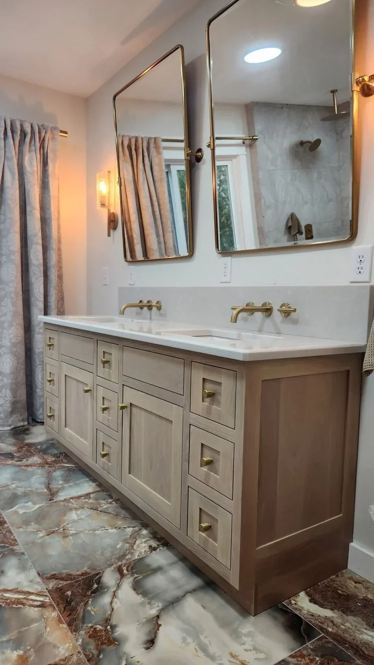 A large white cabinet with multiple doors and black handles in a room with wood flooring.