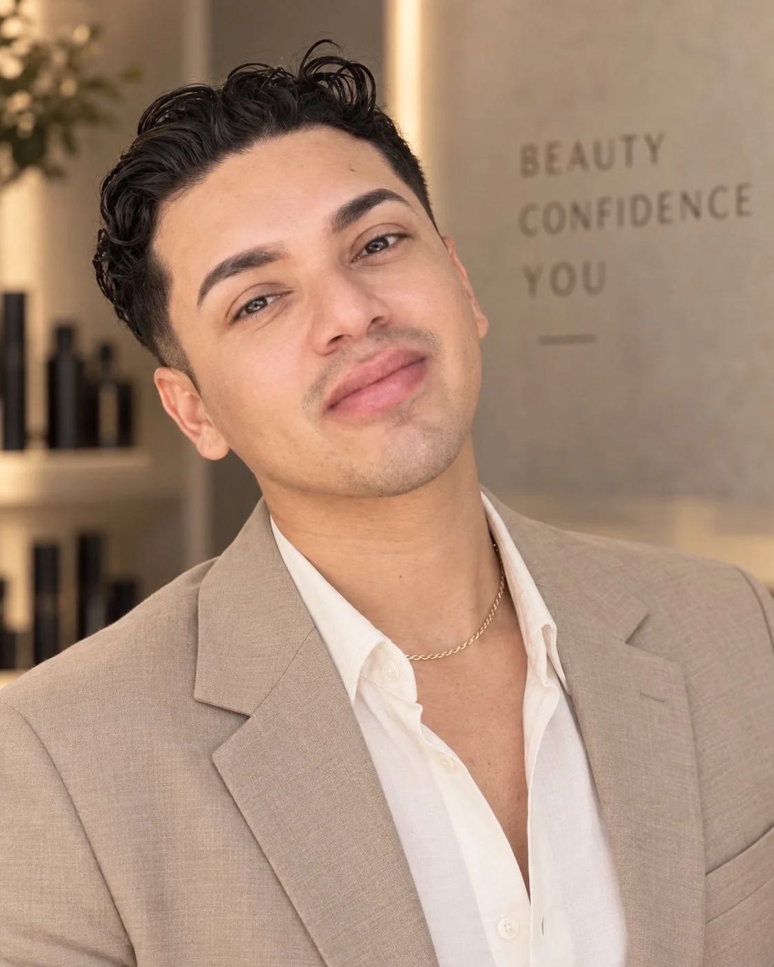 Juan Arevalo Kolevski, co-owner of Simon Styles Co., in a beige suit inside the Pompton Lakes luxury hair salon