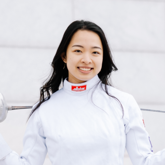 smiling woman with black hair in a white fencing uniform
