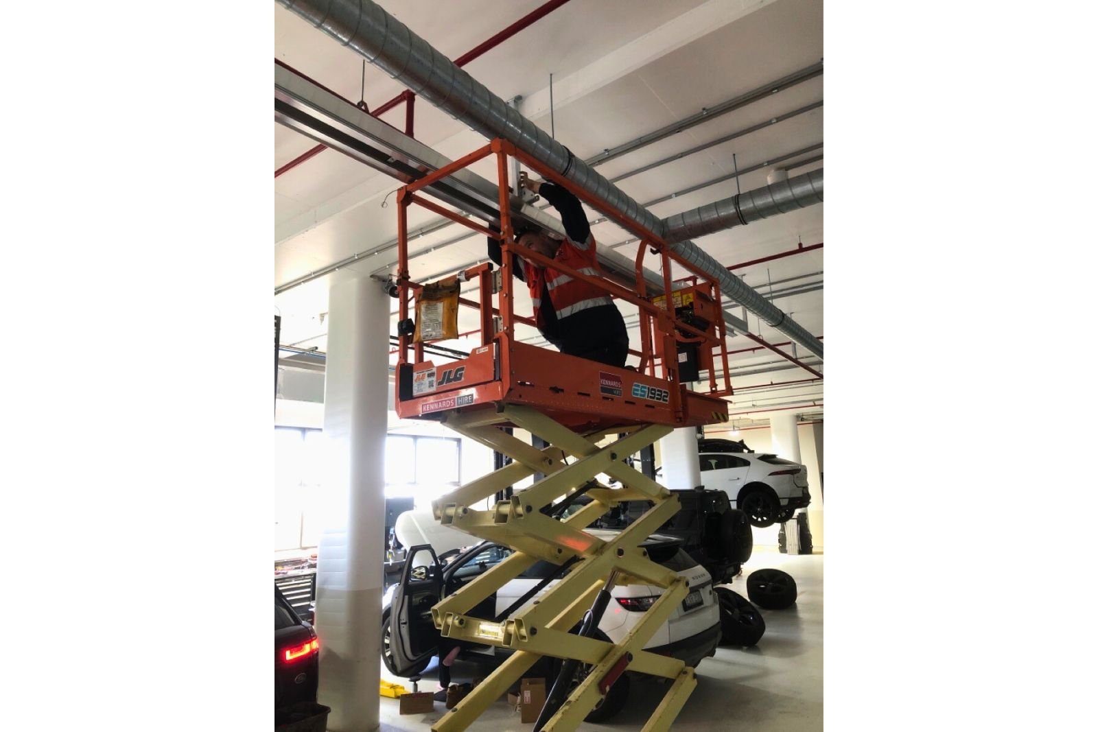 Exhaust ducting installation in progress inside an automotive workshop as part of a full service facility fitout.