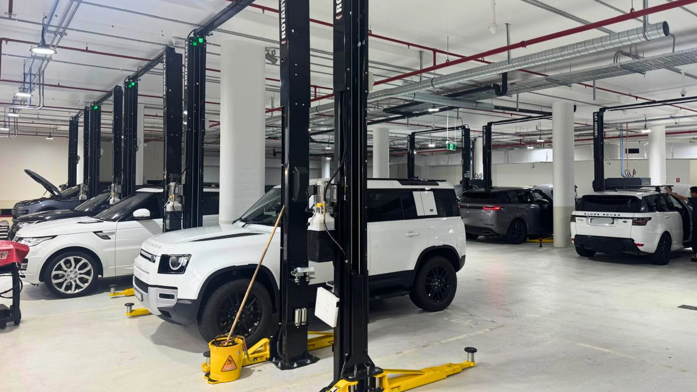 Automotive workshop in Artarmon NSW featuring multiple Rotary two post vehicle hoists installed for dealership servicing.