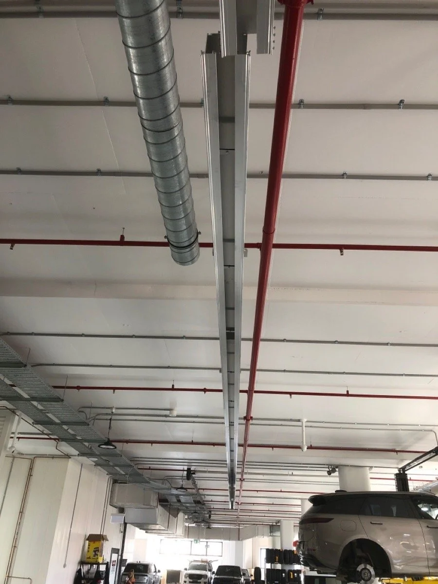 Automotive workshop exhaust ducting installed overhead to support compliant vehicle servicing and ventilation
