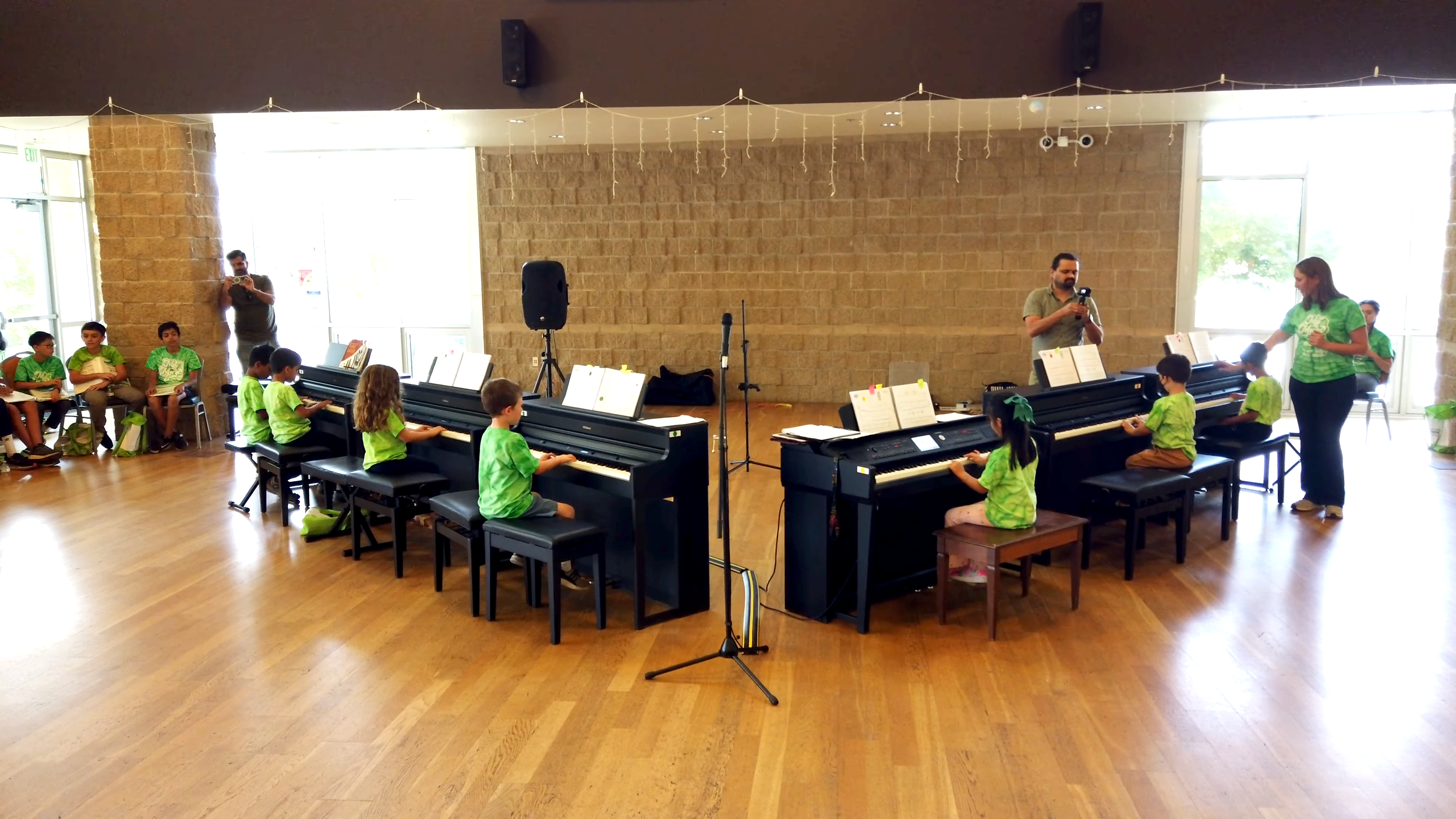 Students perform ensembles with their classmates wearing matching t-shirts.