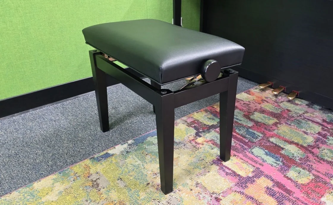 An adjustable, black piano bench with deep cushioned seat.