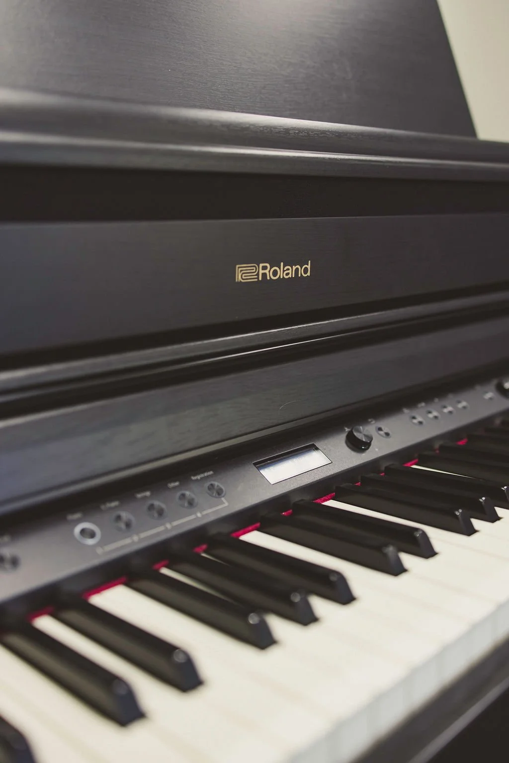 A view of a piano keyboard from the low end of the piano. There's a green background behind it.