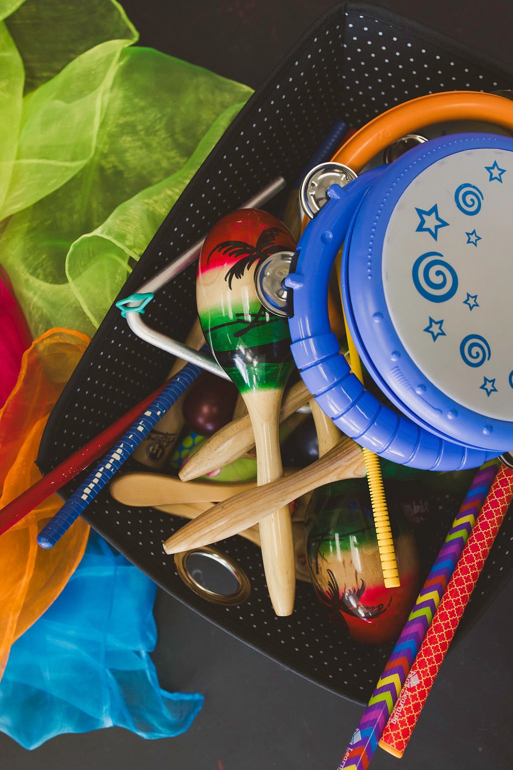 A collection of music class props, including tambourines, rhythm sticks, shakers, and floaty scarves.