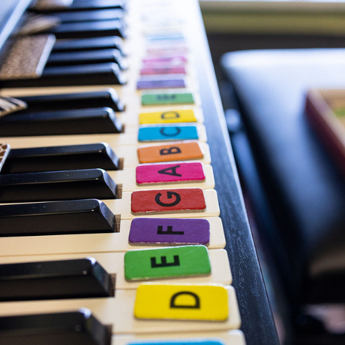 Piano keys with brightly-colored music alphabet tiles