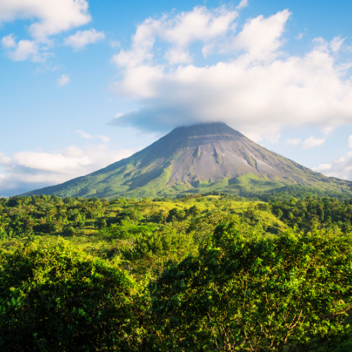A mountain in Costa Rica, surrounded by rainforest and just under a cloud