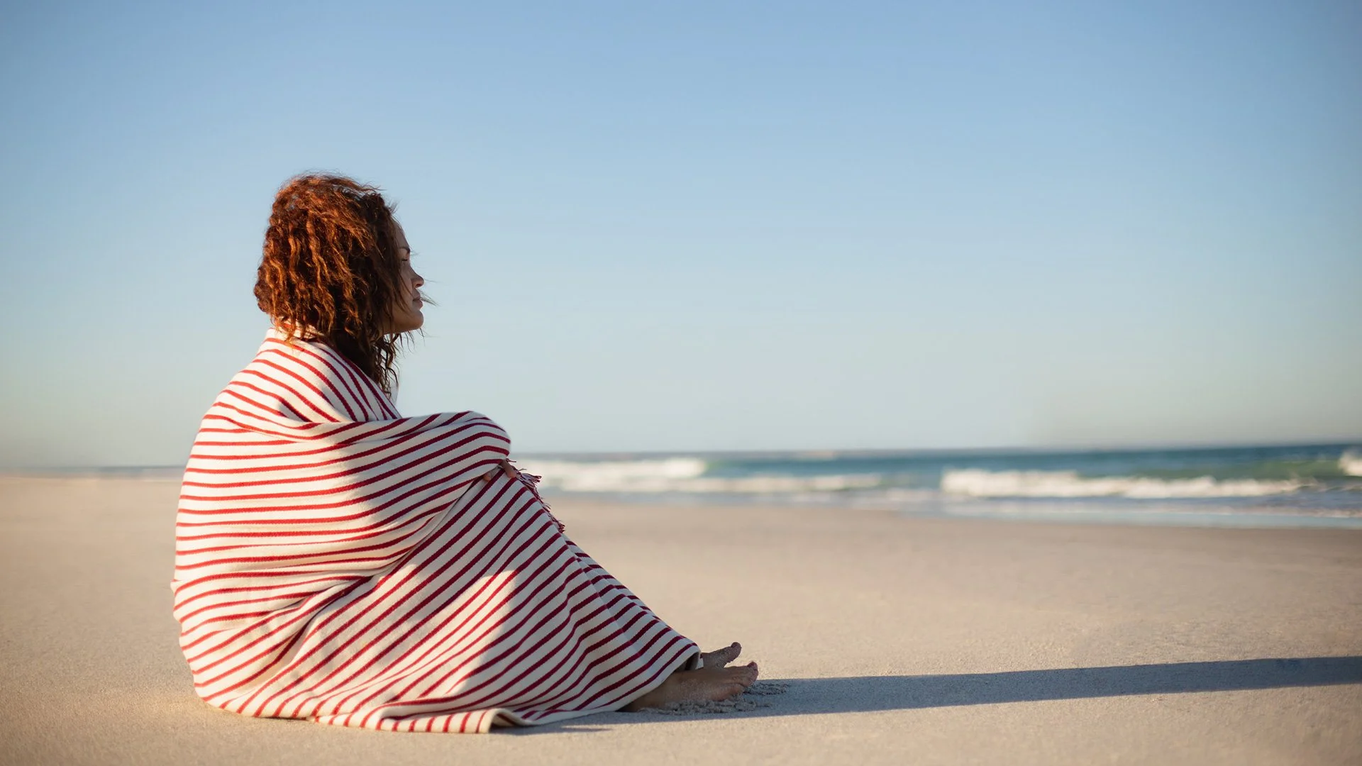 Mother navigating divorce, pensive on the beach