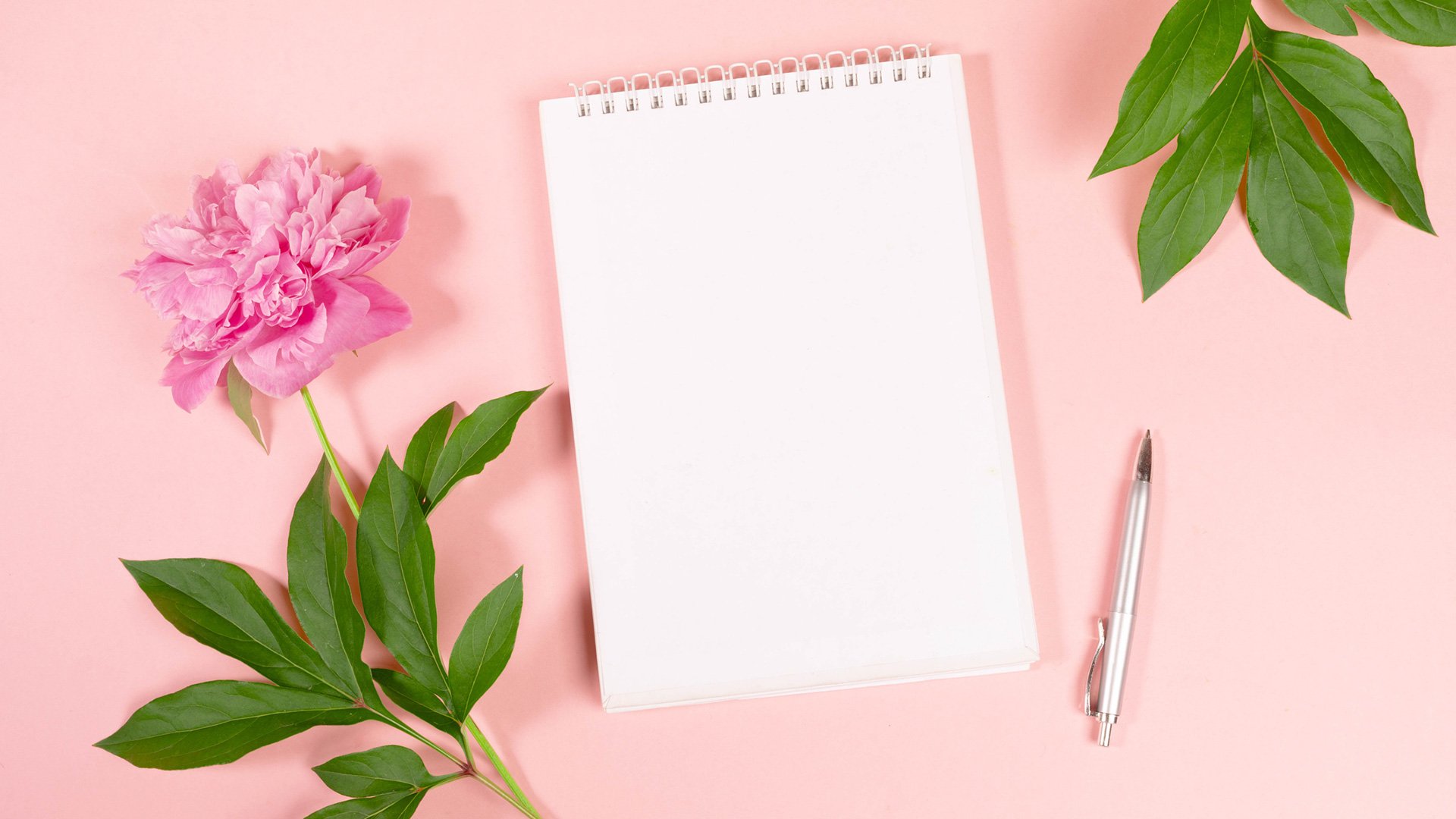blank notepad and pen with flowers for a divorcing mom to write a birthday letter to herself