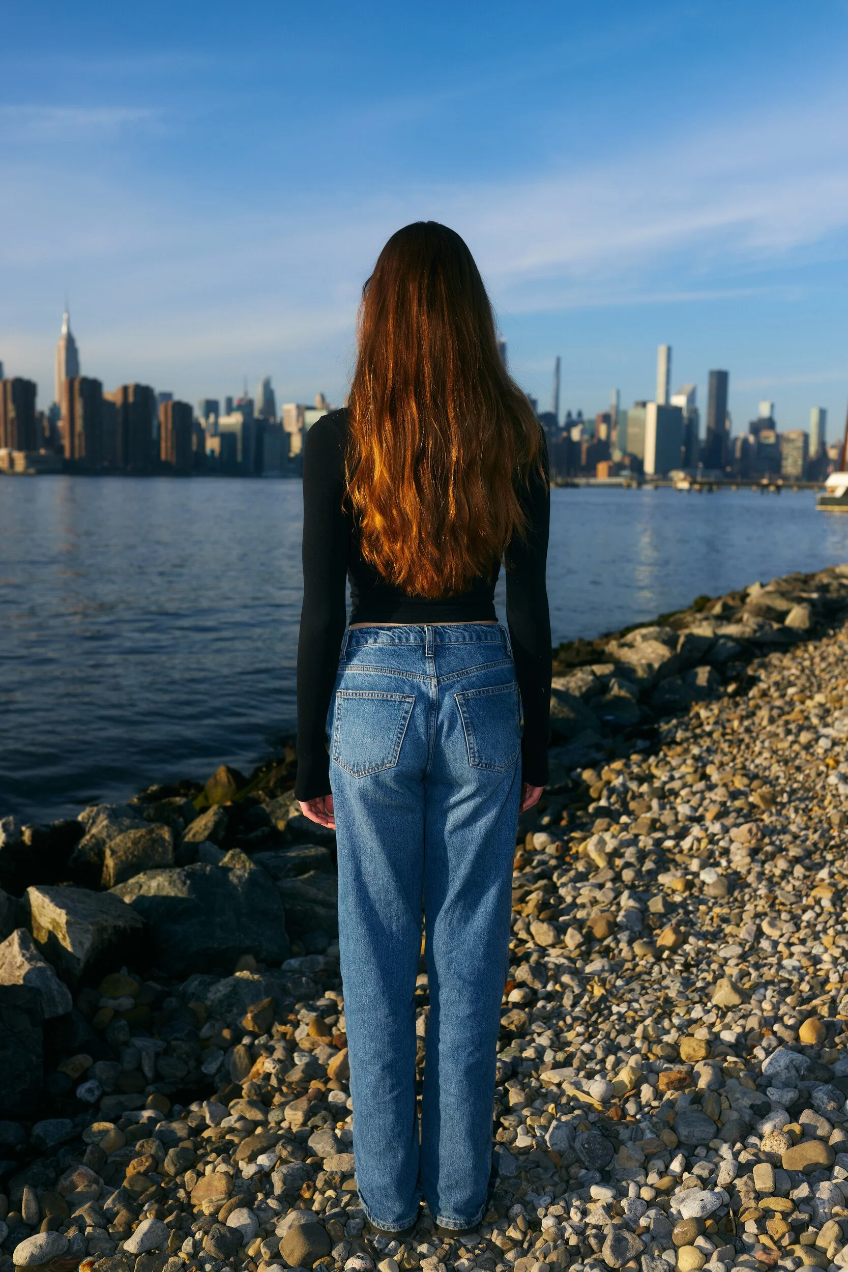 Model digitals by the river: back view of the female model