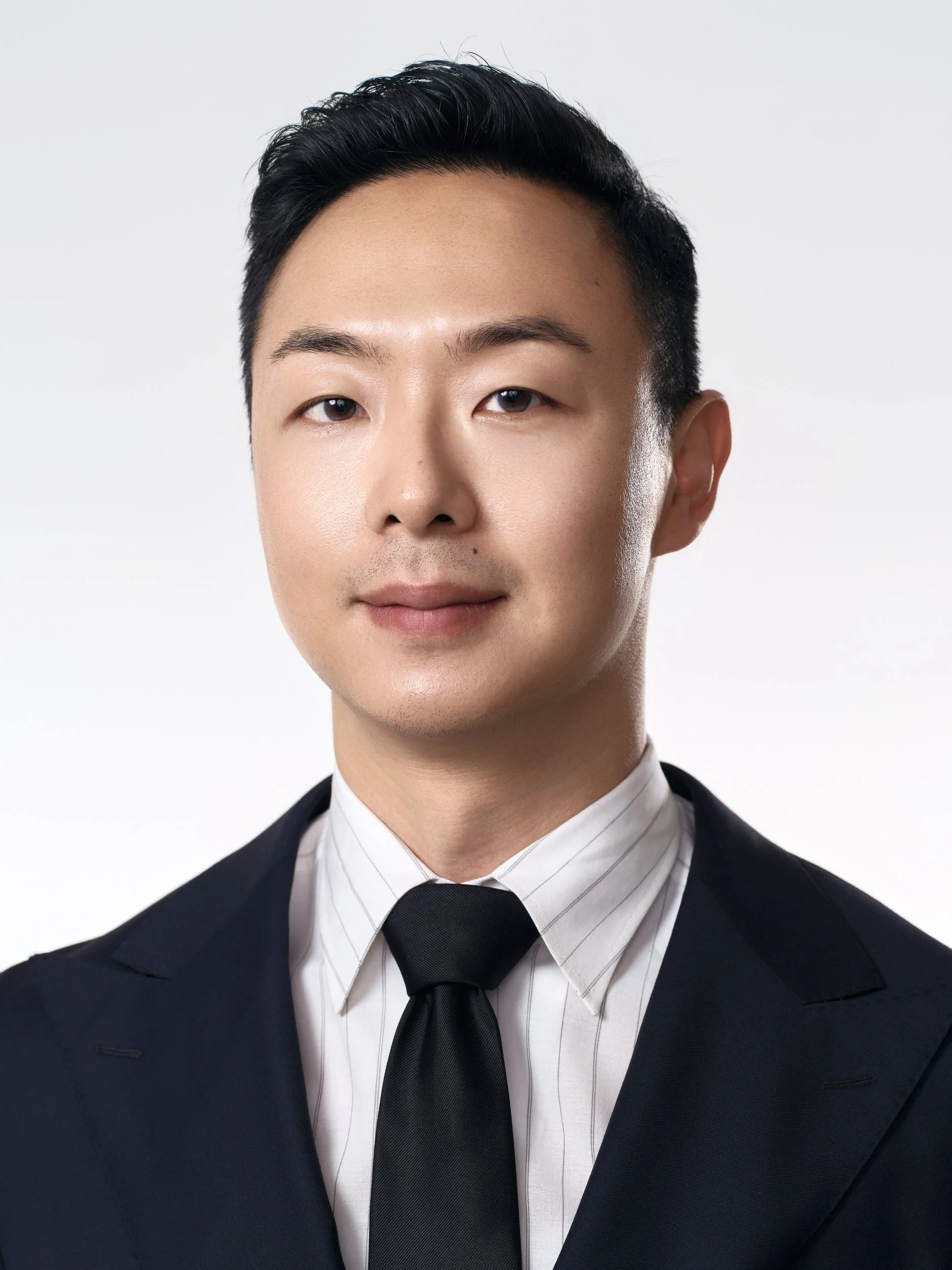 Corporate headshot of a man in a navy double-breasted suit