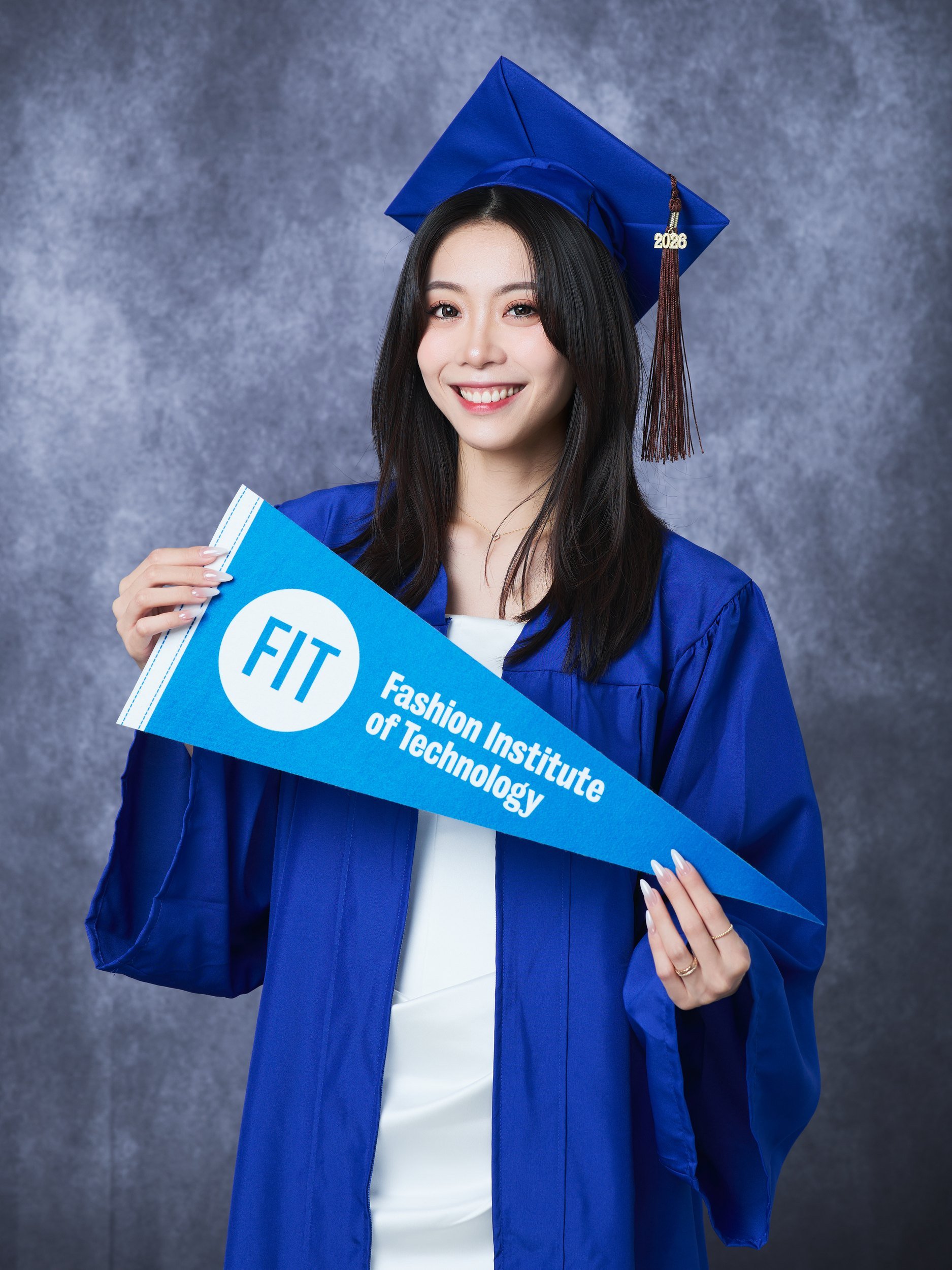 Graduation portrait of a woman in a blue gown holding a pennant