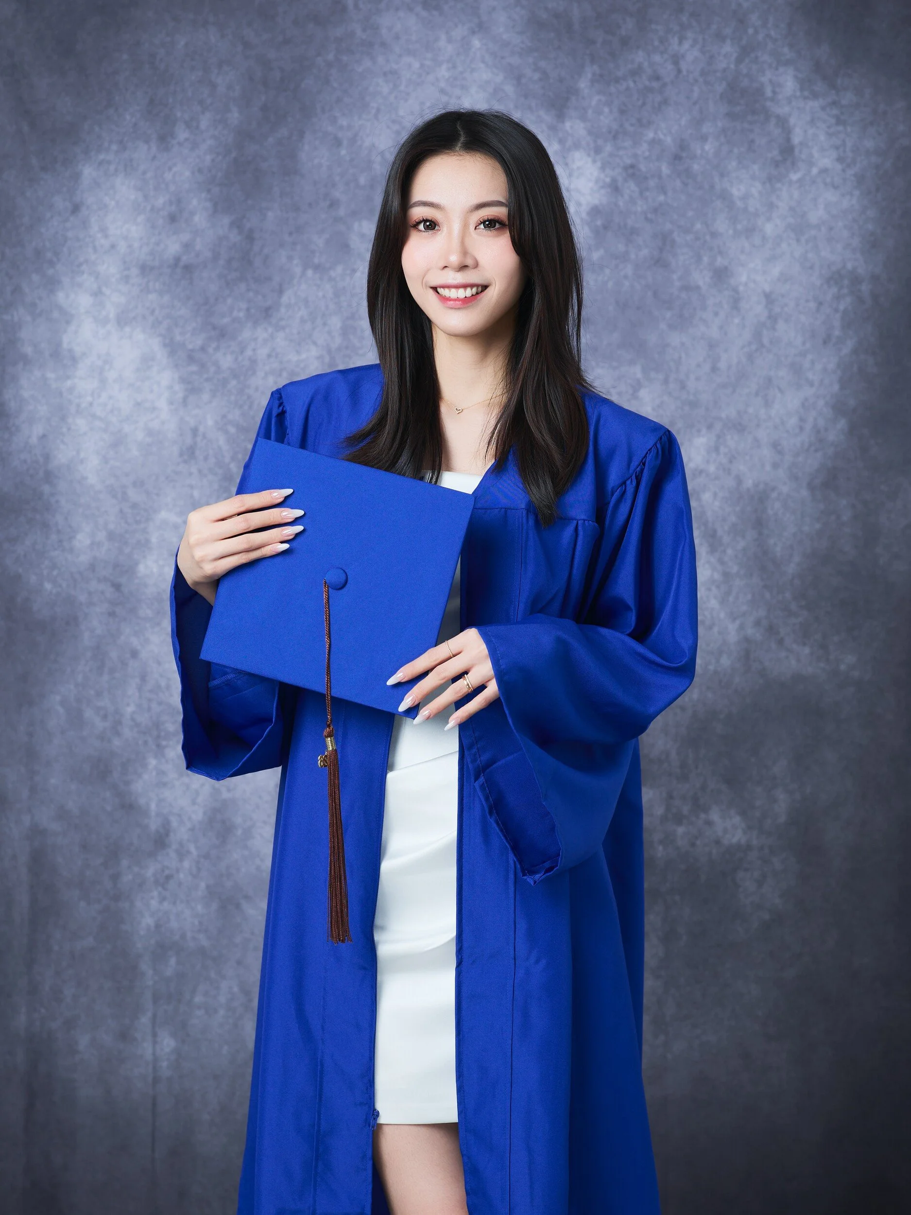 FIT graduate holding her royal blue cap