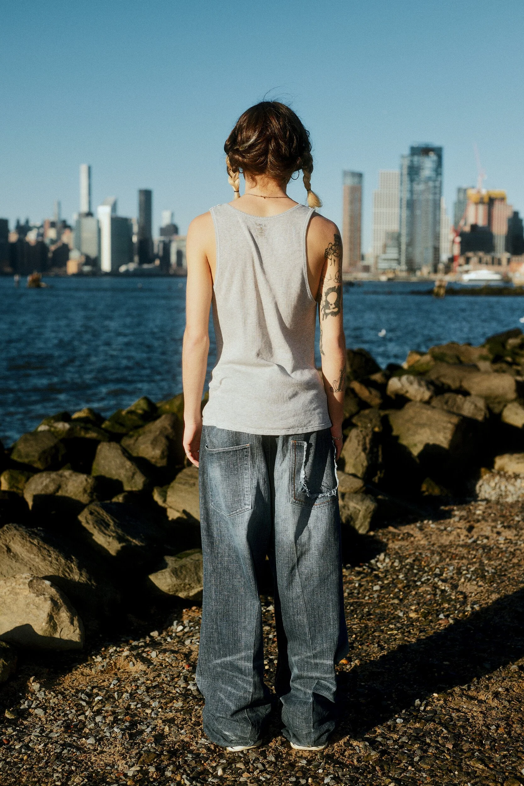Model digitals by the river: back view of the male model