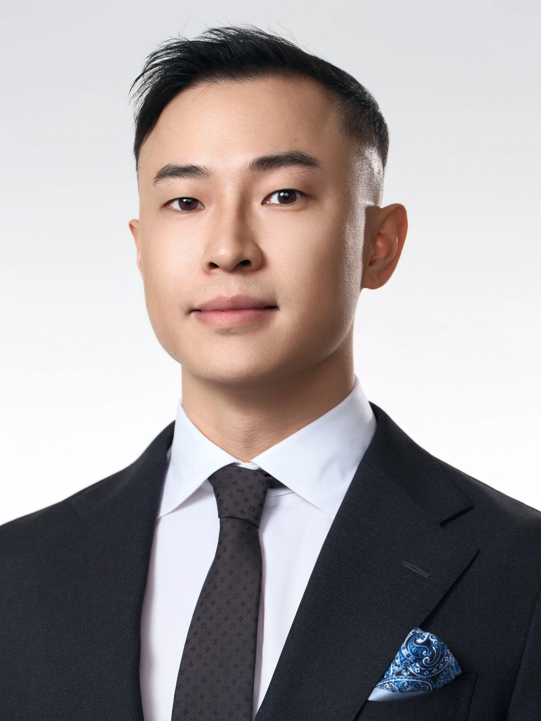 Corporate headshot of a man in a dark suit with a pocket square