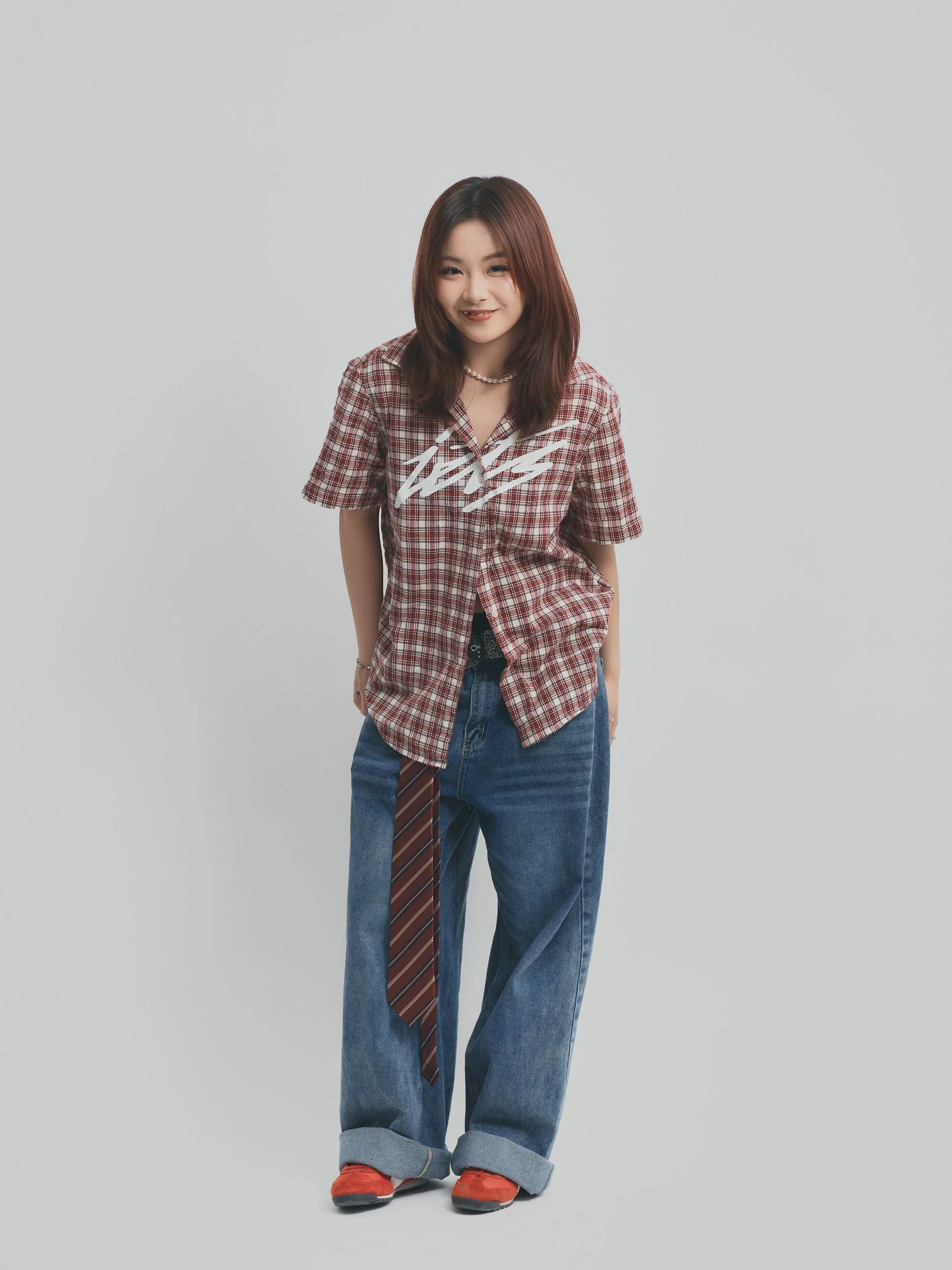 Model test full-length shot of a woman in a plaid shirt and wide-leg jeans