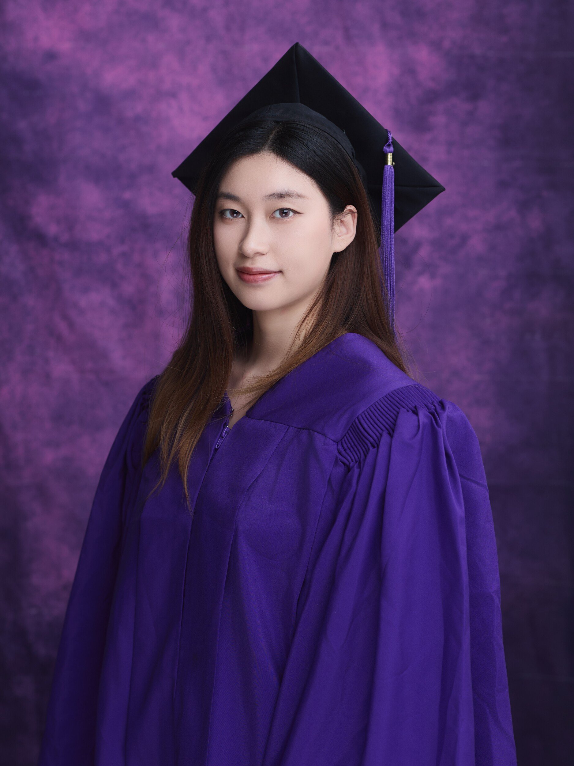 NYU graduation portrait of a woman with long hair and a mortarboard
