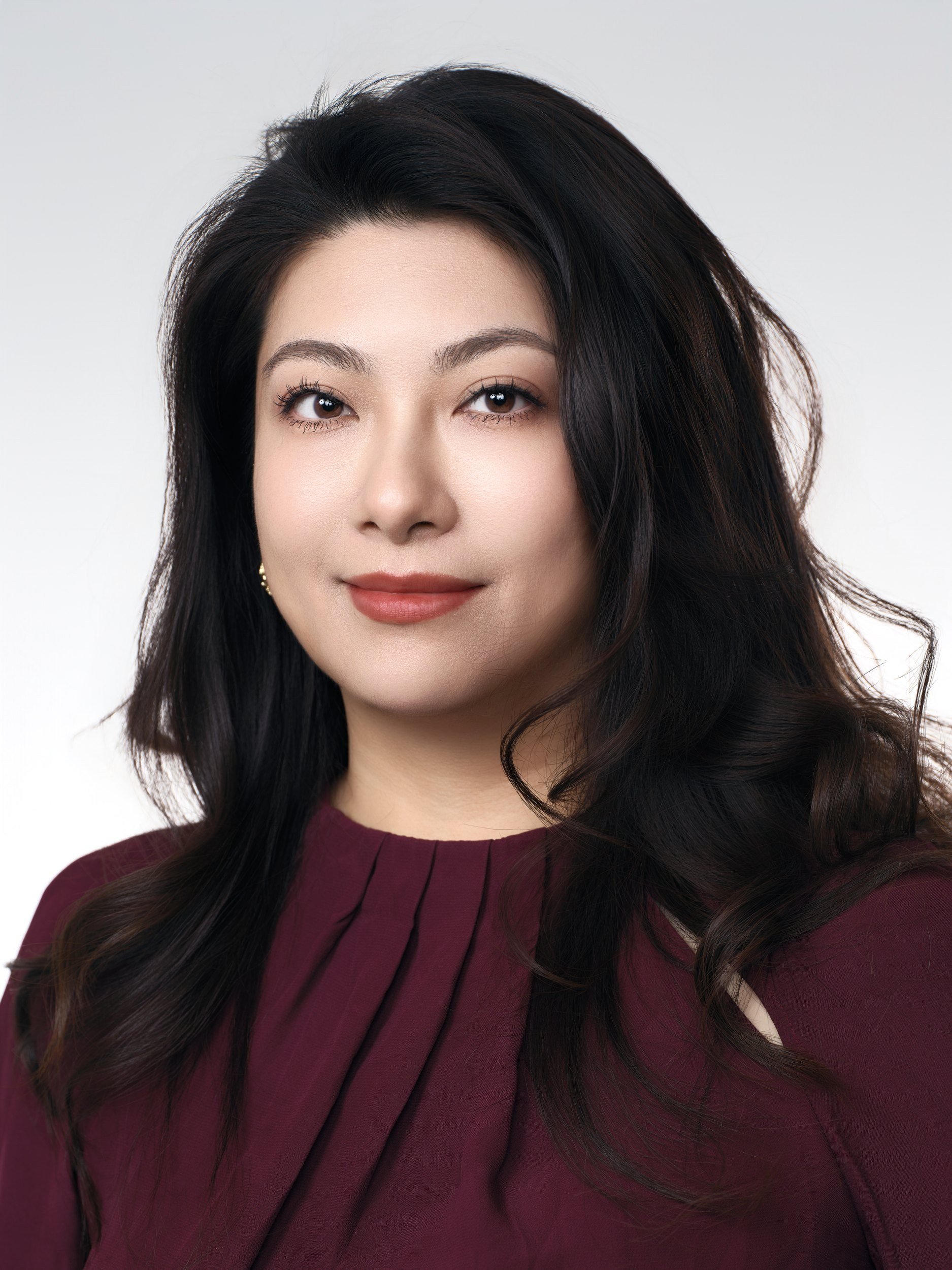 Corporate headshot of a woman in a burgundy blouse
