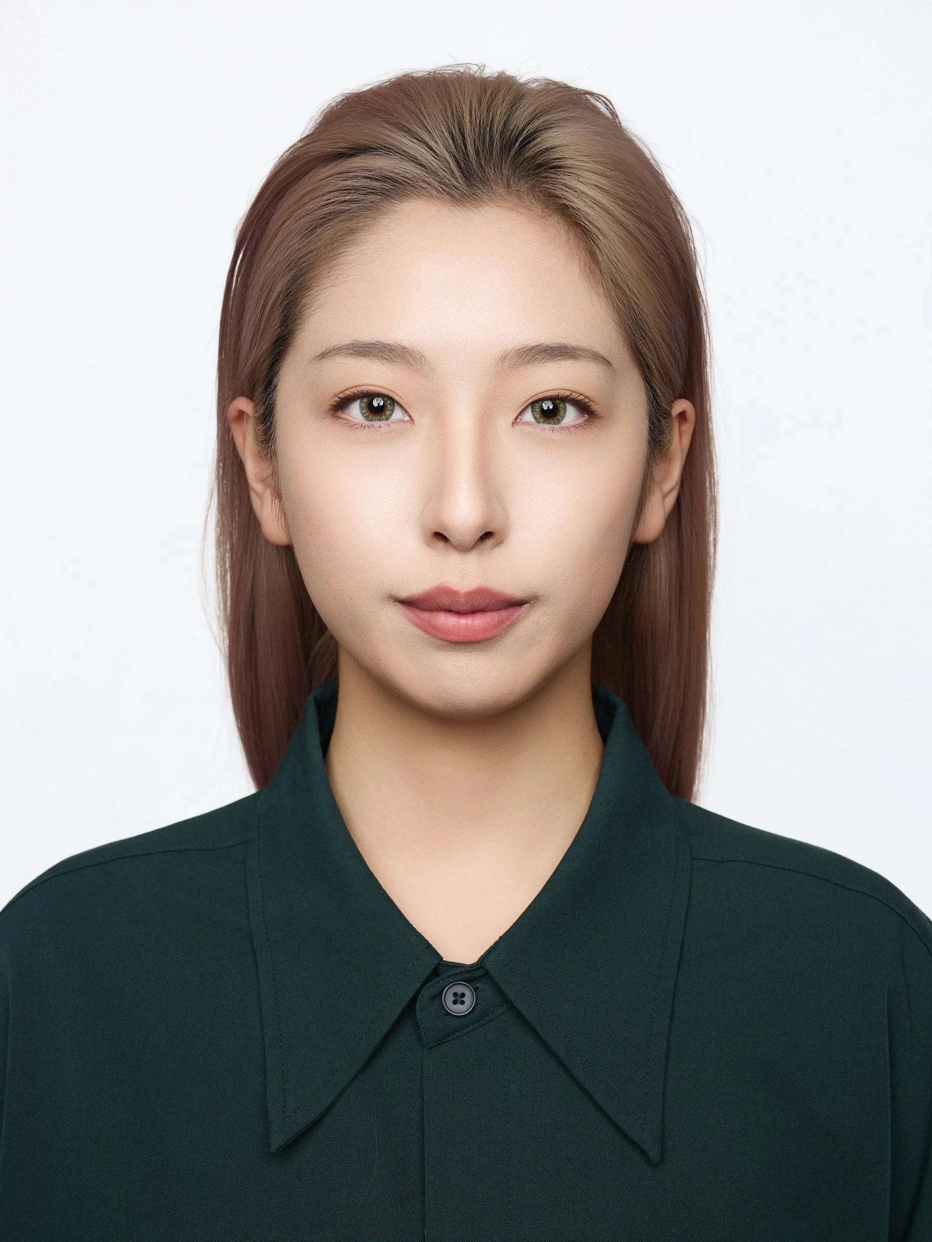 Front-facing ID-style headshot of a woman in a dark green shirt