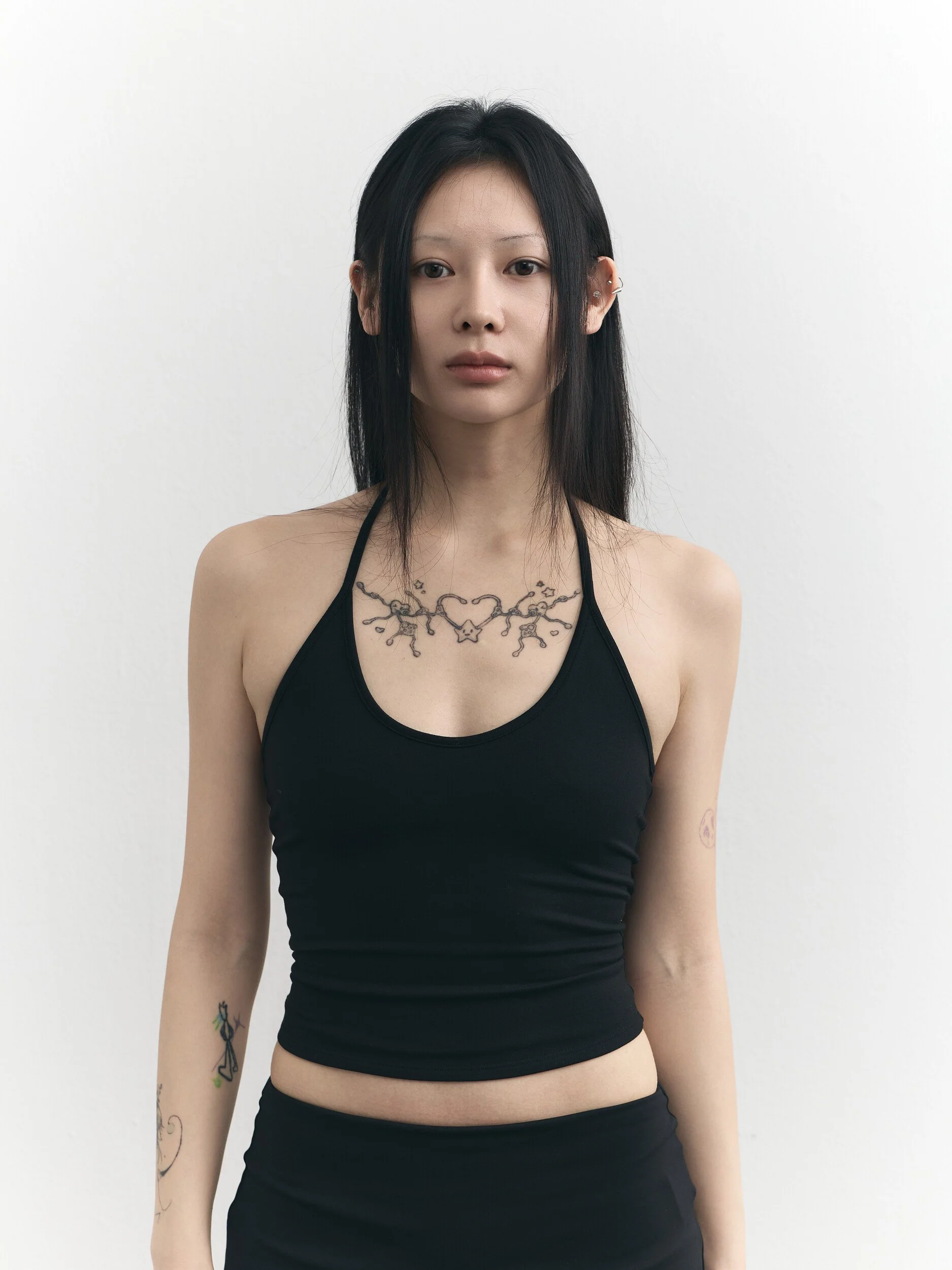 Model digitals: waist-up front view of the model in a black halter top
