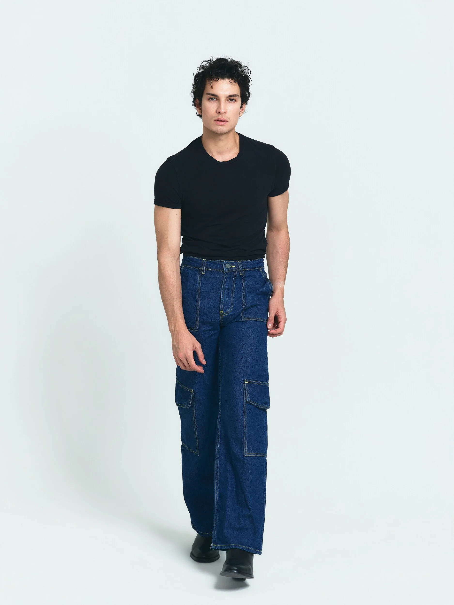 Model digitals: full-length walking shot of the model in a black T-shirt and wide-leg jeans